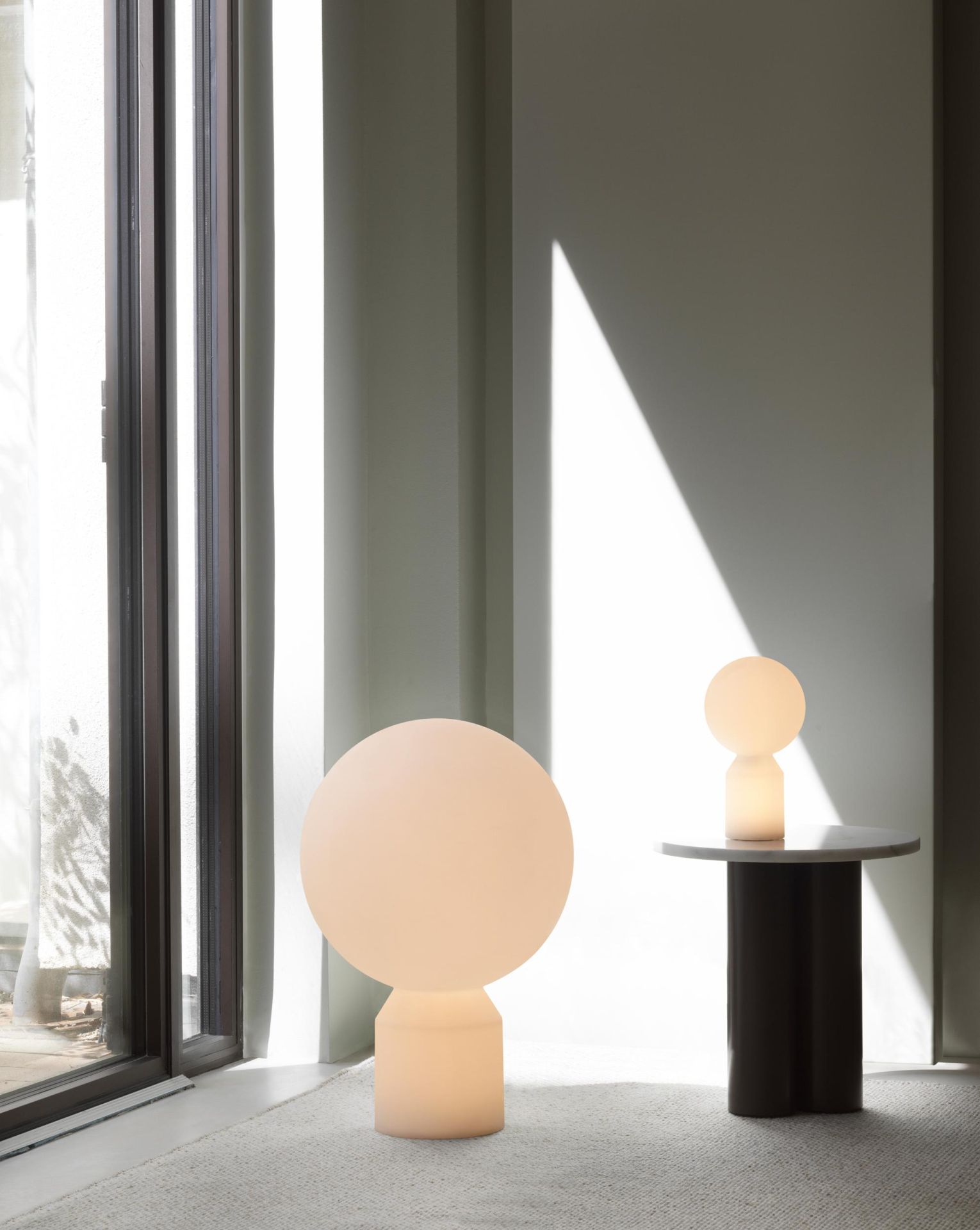 Normann Copenhagen Dit Coffee Table Beistelltisch mit zwei modernen, runden Lampen in einem hellen, minimalistischen Raum.