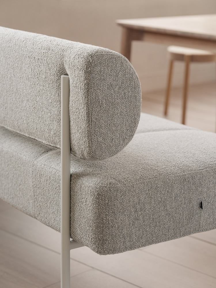 Detailaufnahme des Daybe Esszimmersofas mit grauem Stoffbezug und minimalistischem Design.
