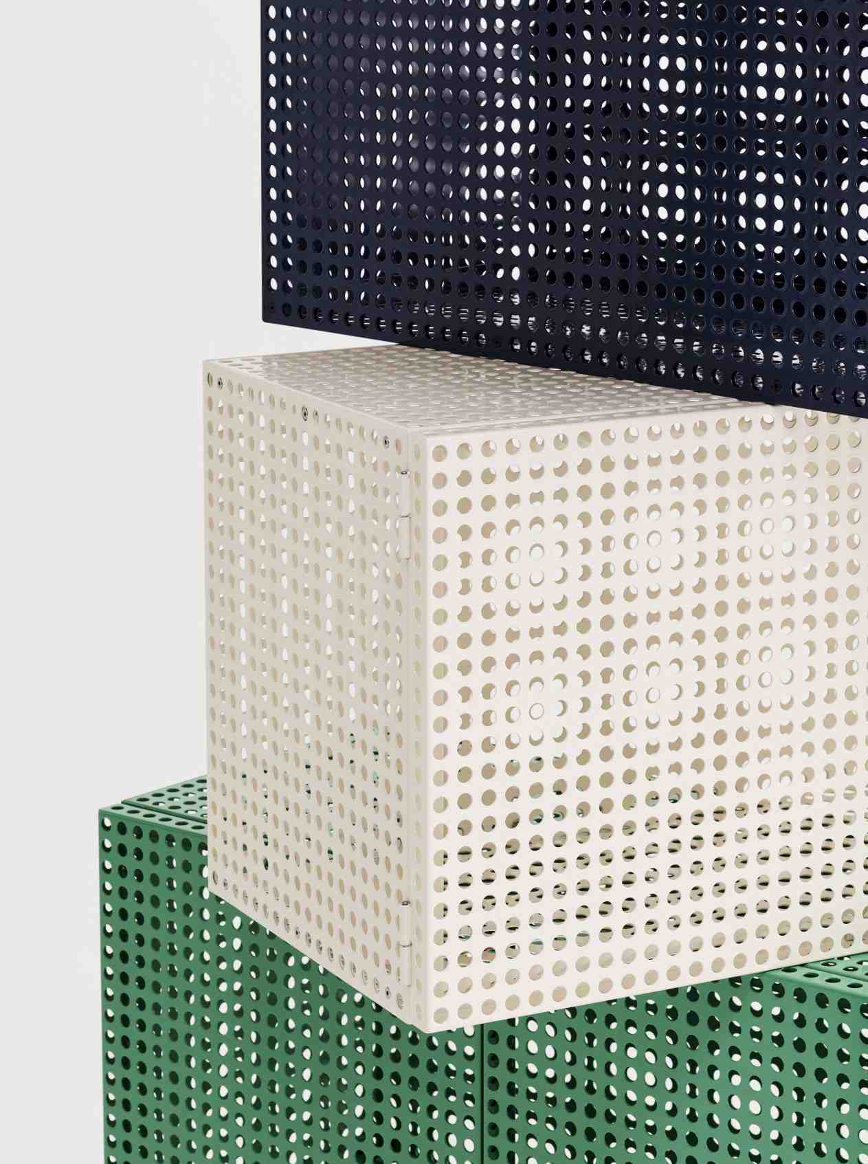 Detailaufnahme von drei Hay Perforated Cabinet Wall Sideboards in Grün, Weiß und Dunkelblau, gestapelt.