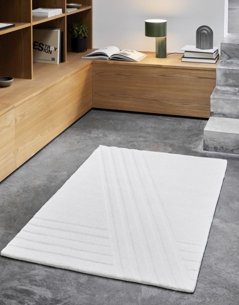 Weißer Kyoto Teppich von Woud, 90x140 cm, mit geometrischem Muster auf grauem Boden.