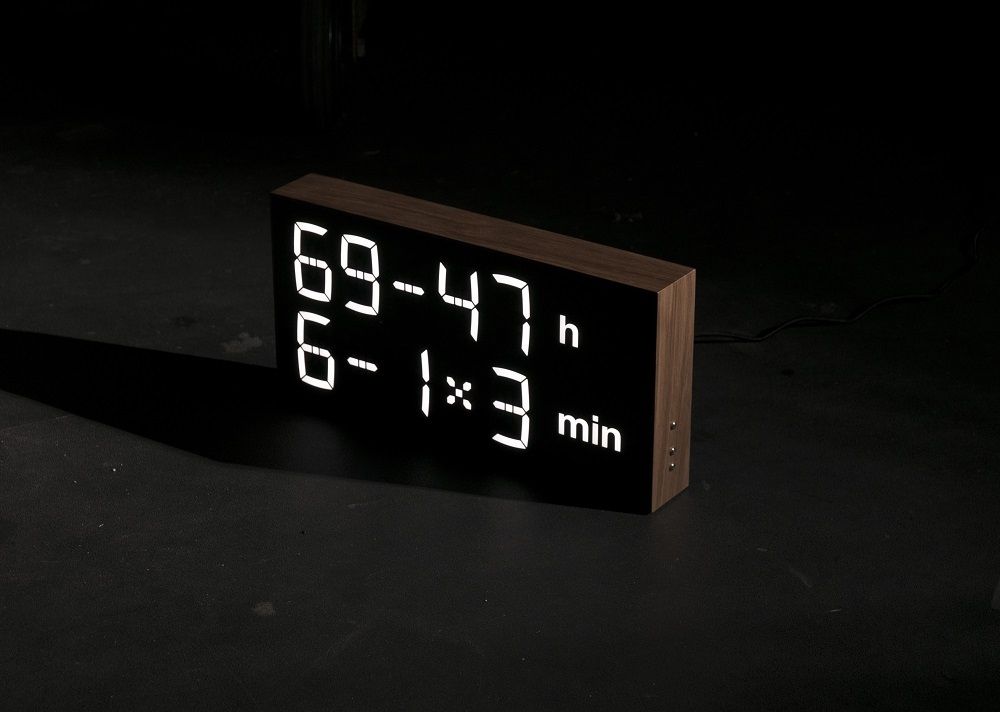 Schwarze Albert Clock LED Digitaluhr mit Holzrahmen, zeigt Uhrzeit und Datum an.