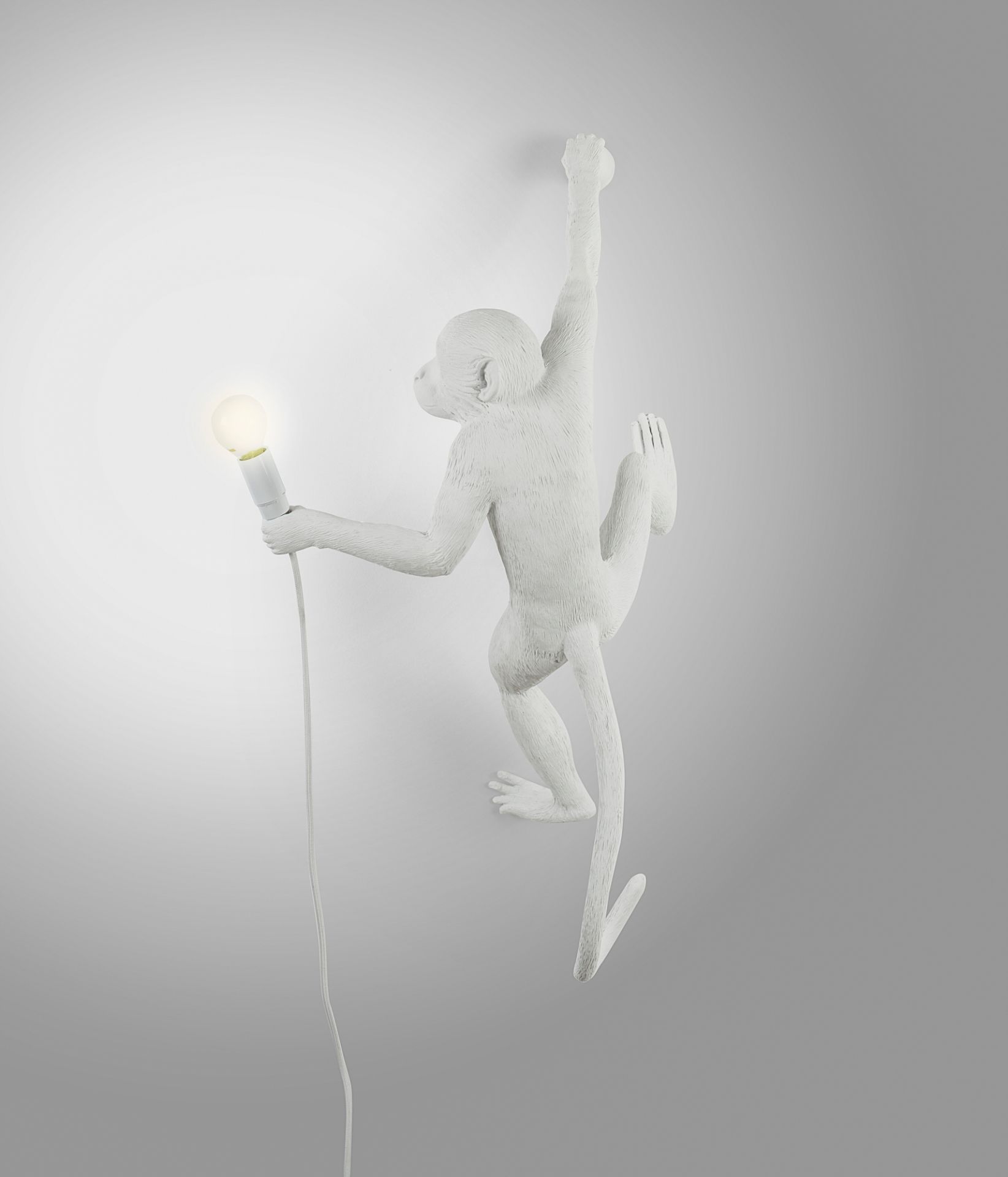Weiße Monkey Lamp Wandleuchte (rechts) von Seletti: Affe hält eine Glühbirne an der Wand.