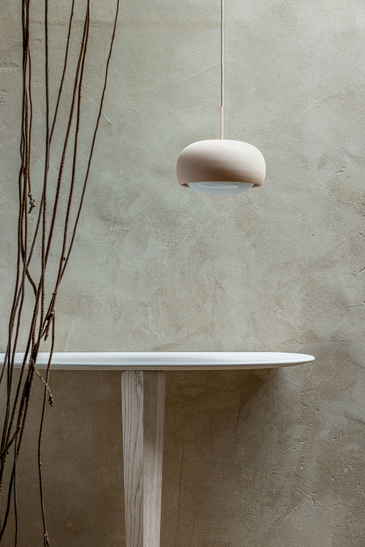 Kuyu Console Konsolentisch aus Holz, minimalistisches Design mit Lampe und Ästen vor einer beigen Wand.