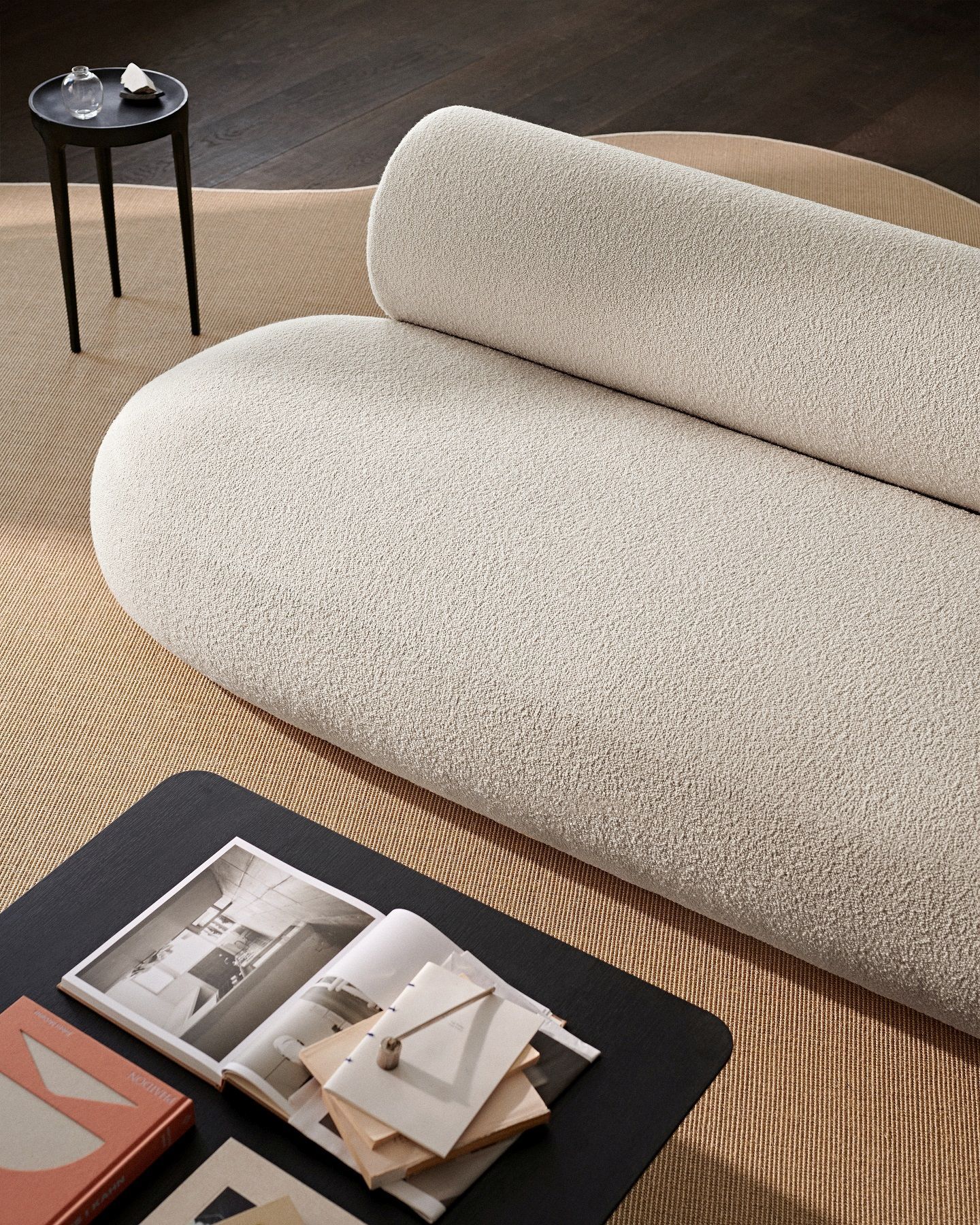 Nahaufnahme des Hippo Sofa von Norr11 in Beige mit Bouclé-Stoff, kombiniert mit Couchtisch und Teppich.