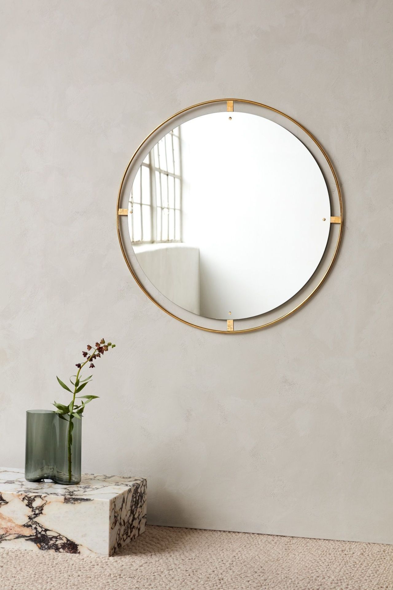 Runder Nimbus Mirror Spiegel von Audo Copenhagen mit goldenem Rahmen an einer Wand.