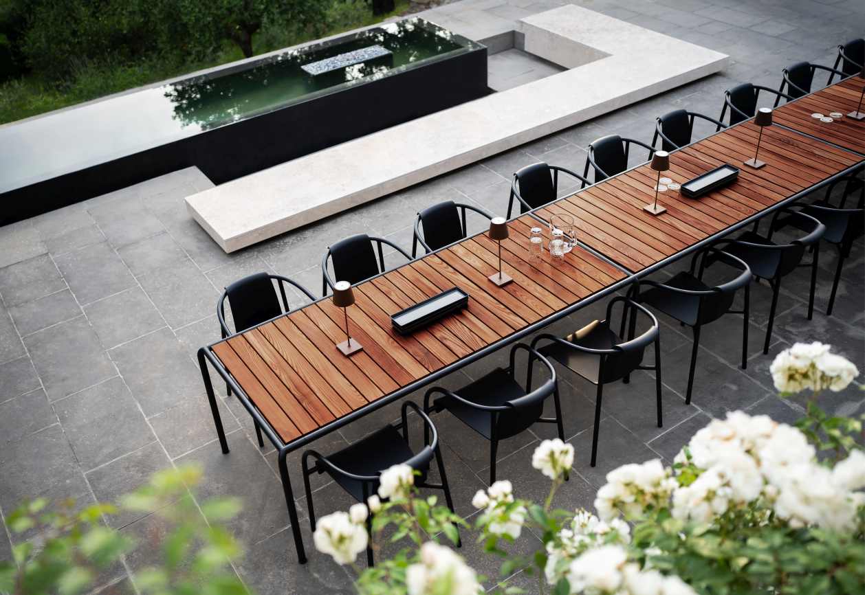 Avanti Dining Table Esstisch Outdoor von Houe mit schwarzen Stühlen und Holztischplatte im Garten.