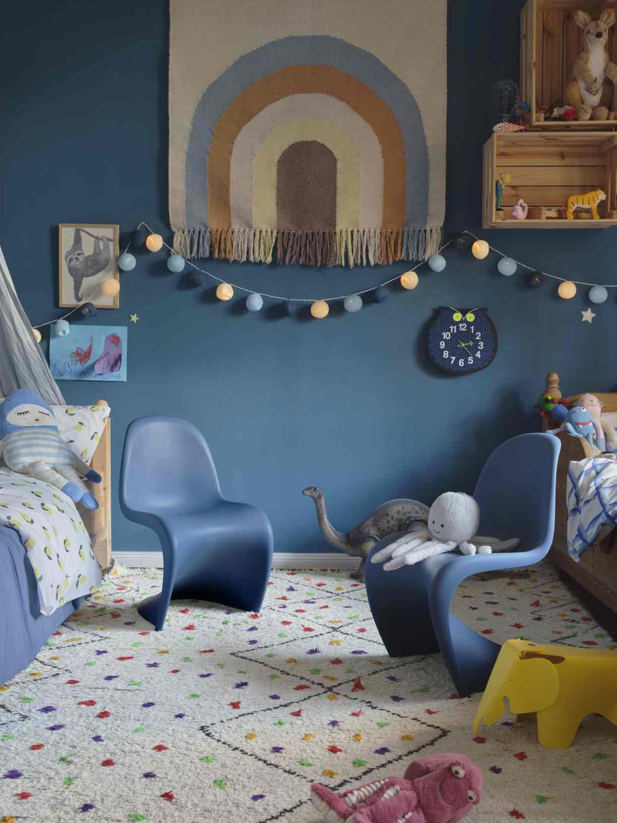 Kinderzimmer mit Vitra Panton Stühlen, Spielzeug und einer Omar the Owl Eulen Wanduhr als Blickfang.