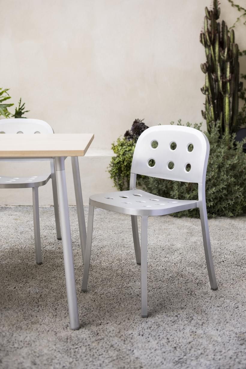 Emeco 1 Inch Aluminium Stacking Chair: Silberner Design Stuhl mit Löchern im Garten.