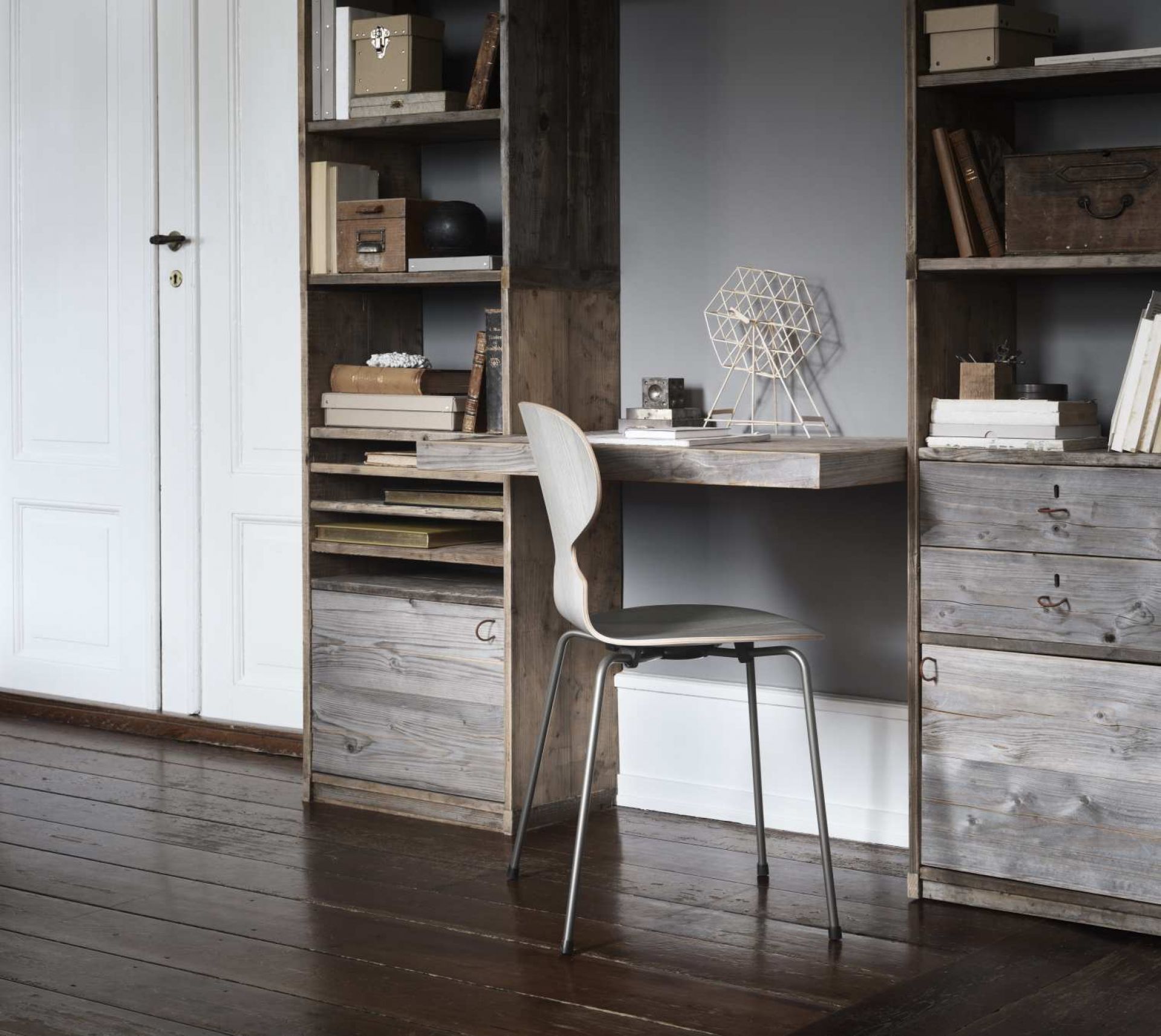 Die Ameise Stuhl von Fritz Hansen mit vierbeinigen Stahlgestell am Schreibtisch im rustikalen Arbeitszimmer.