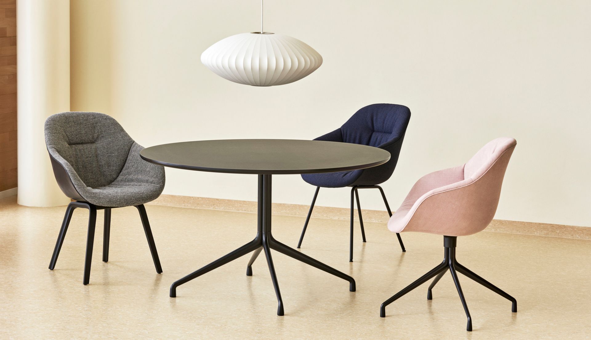 Drei Hay About a Chair AAC 121 Soft Duo Stühle in Grau, Blau und Rosa um einen Tisch.
