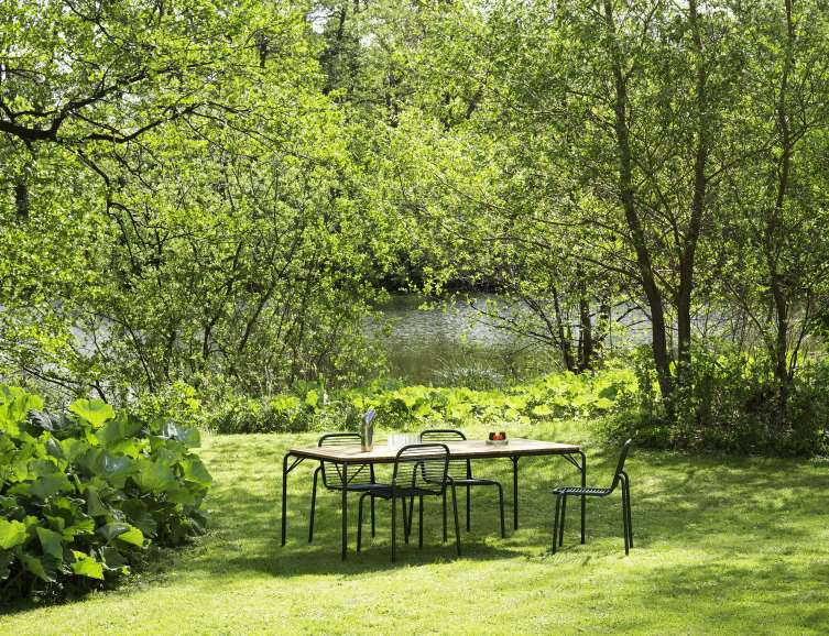 Normann Copenhagen Vig Table Outdoor mit Stühlen im Garten am See. Gartentisch aus Holz.