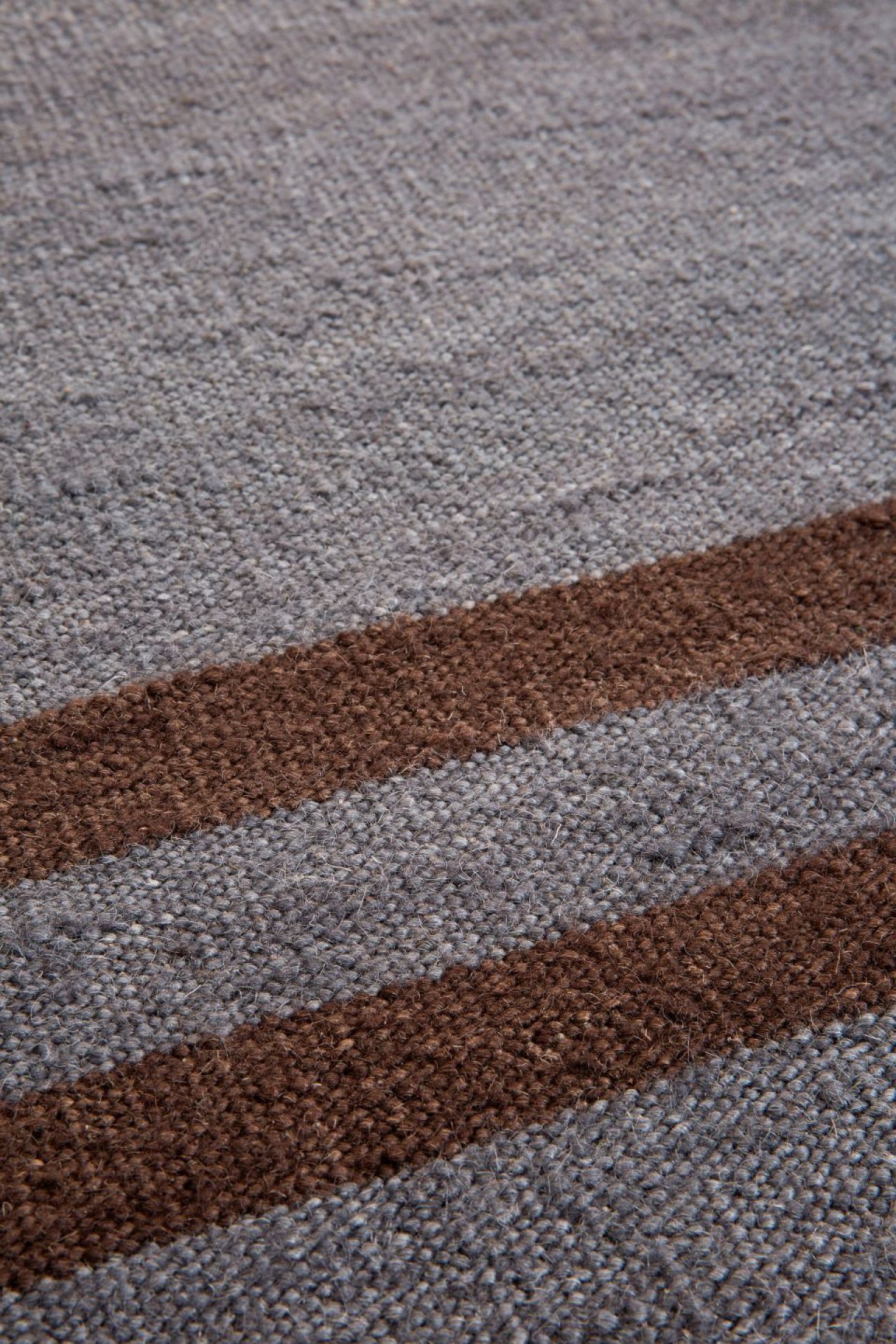 Detailaufnahme des grauen Mazandaran Kilim Teppichs mit braunen Streifen, Ethno-Muster und Textur.