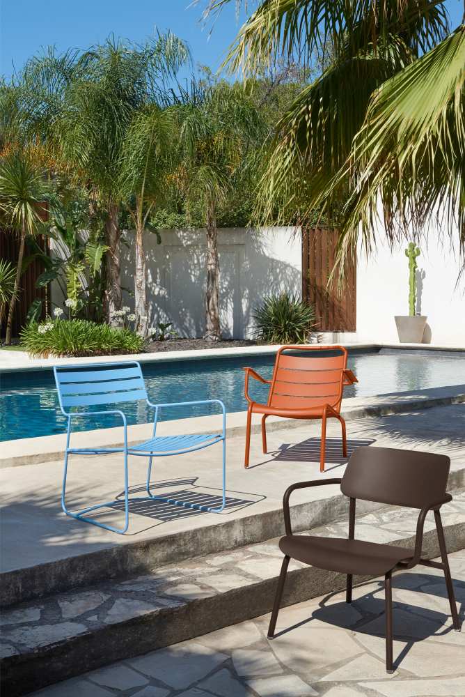 Drei farbige Fermob Studie Lounge Sessel Outdoor am Pool, modernes Gartenmöbel Design für Terrasse.