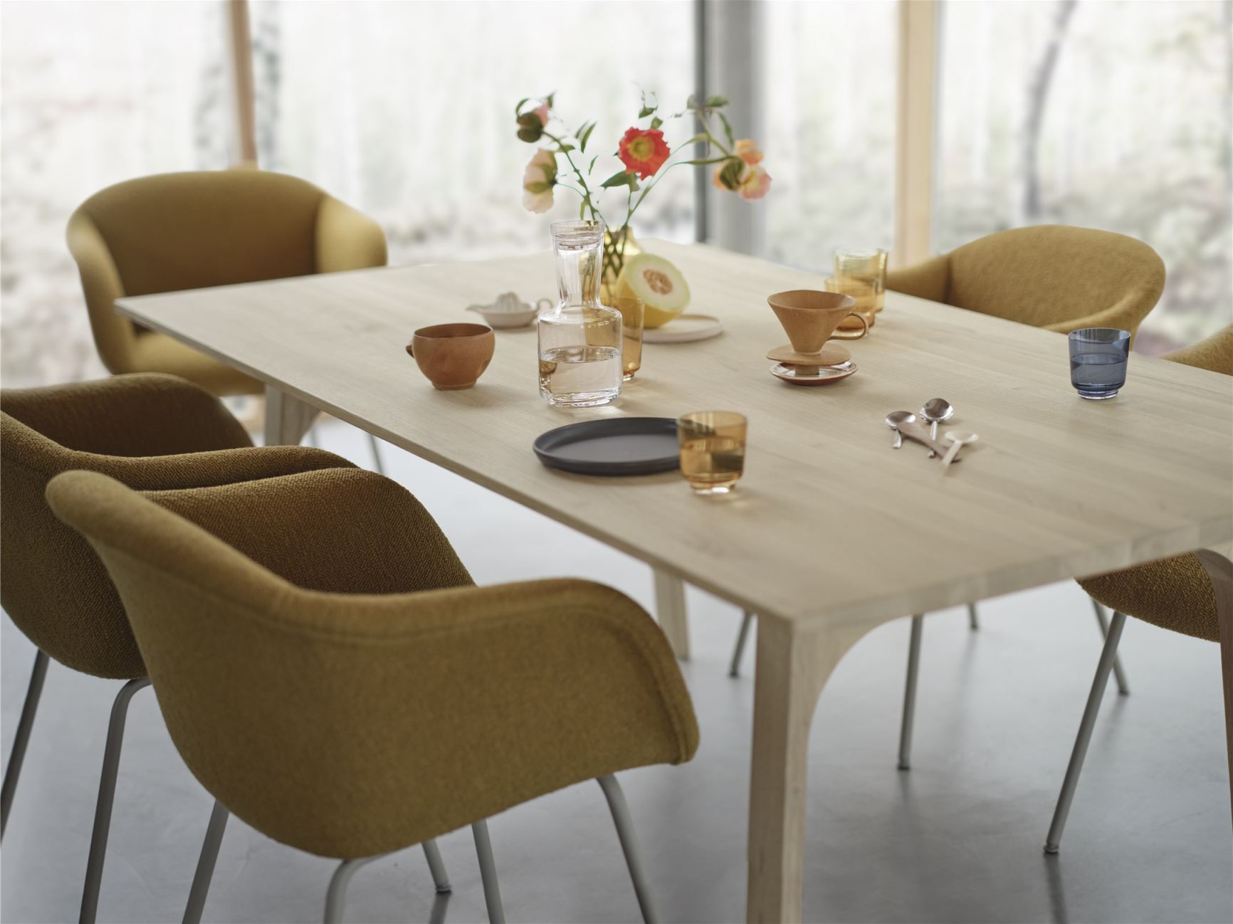 Earnest Esstisch ausziehbar von Muuto, helle Holzoberfläche mit Gedeck und gelben Stühlen.