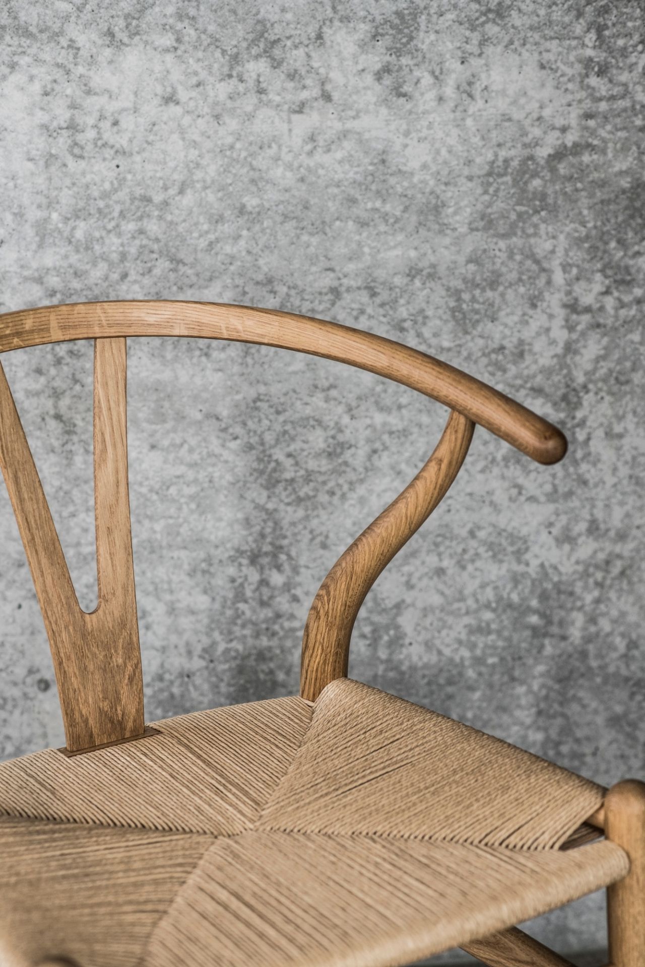 Detailaufnahme des CH24 Wishbone Chair Stuhls von Carl Hansen & Søn mit geflochtener Sitzfläche.