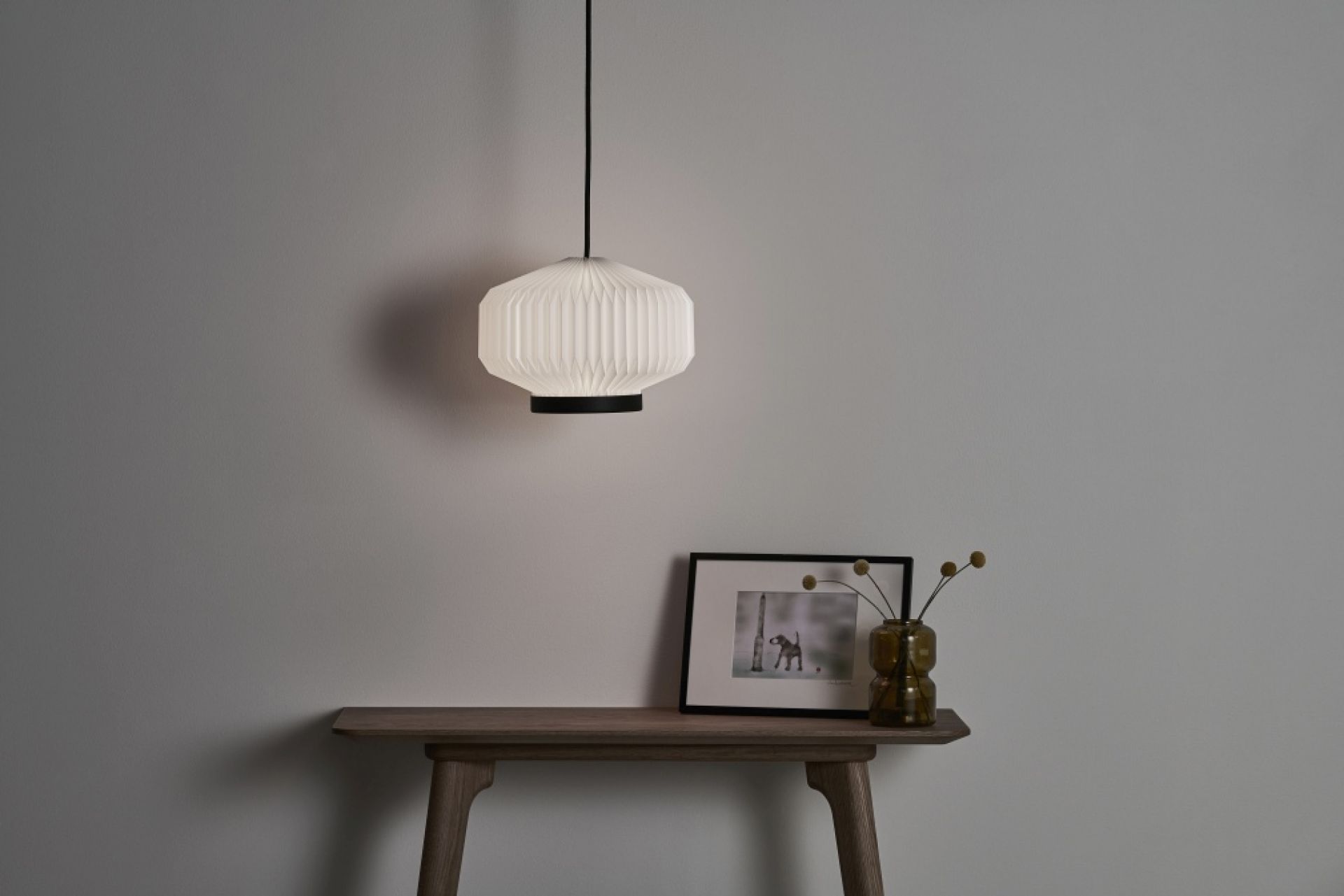 Shibui Pendelleuchte von Le Klint: Hängende Lampe mit plissiertem Lampenschirm und schwarzem Detail.