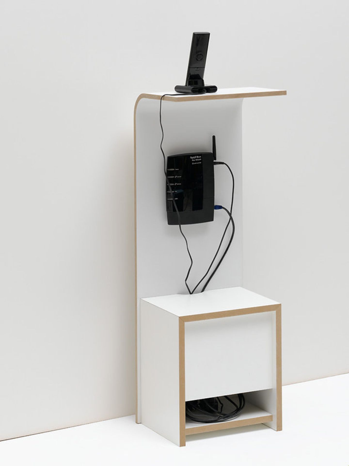 Weißes Tojo Fon Regal mit Router, Telefonhalterung und Kabelführung für moderne Einrichtung.
