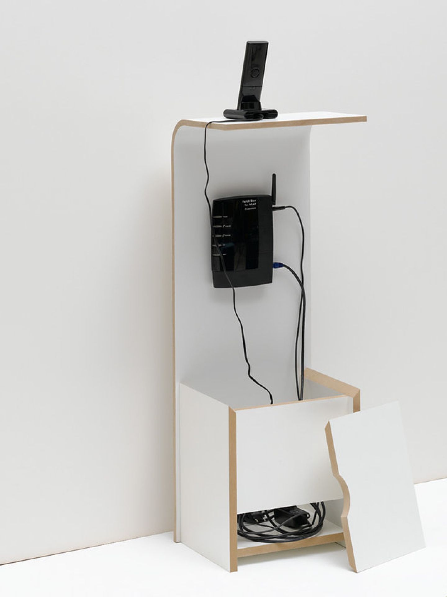 Weißes Fon Regal von Tojo mit Router, Telefon und Kabelsalat zur Aufbewahrung.