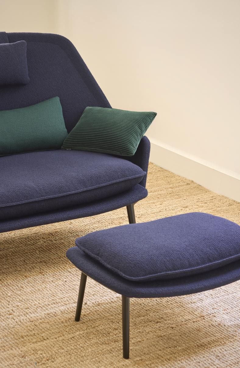 Nahaufnahme des Slow Sofas von Vitra mit blauem Stoffbezug und passendem Hocker.