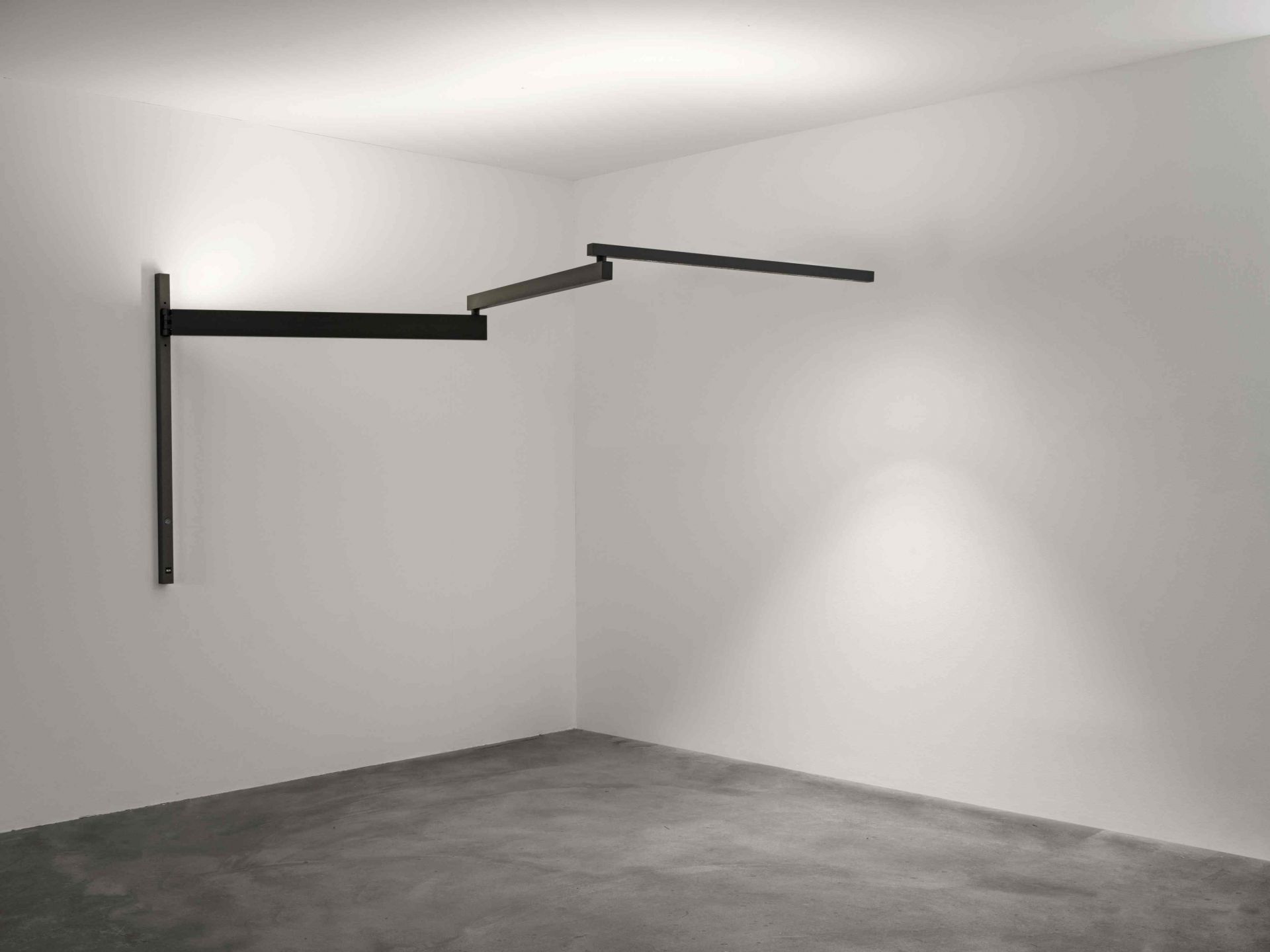 Schwarze Flos Wandleuchte "Black Flag" im minimalistischen Design, montiert an einer weißen Wand in einem leeren Raum.