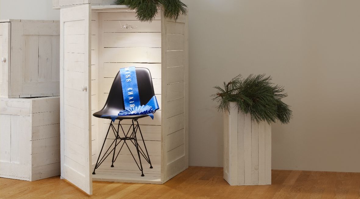 Schwarzer Eames DSR Stuhl von Vitra mit blauem "Miss Chair" Band in weißer Holzkabine.
