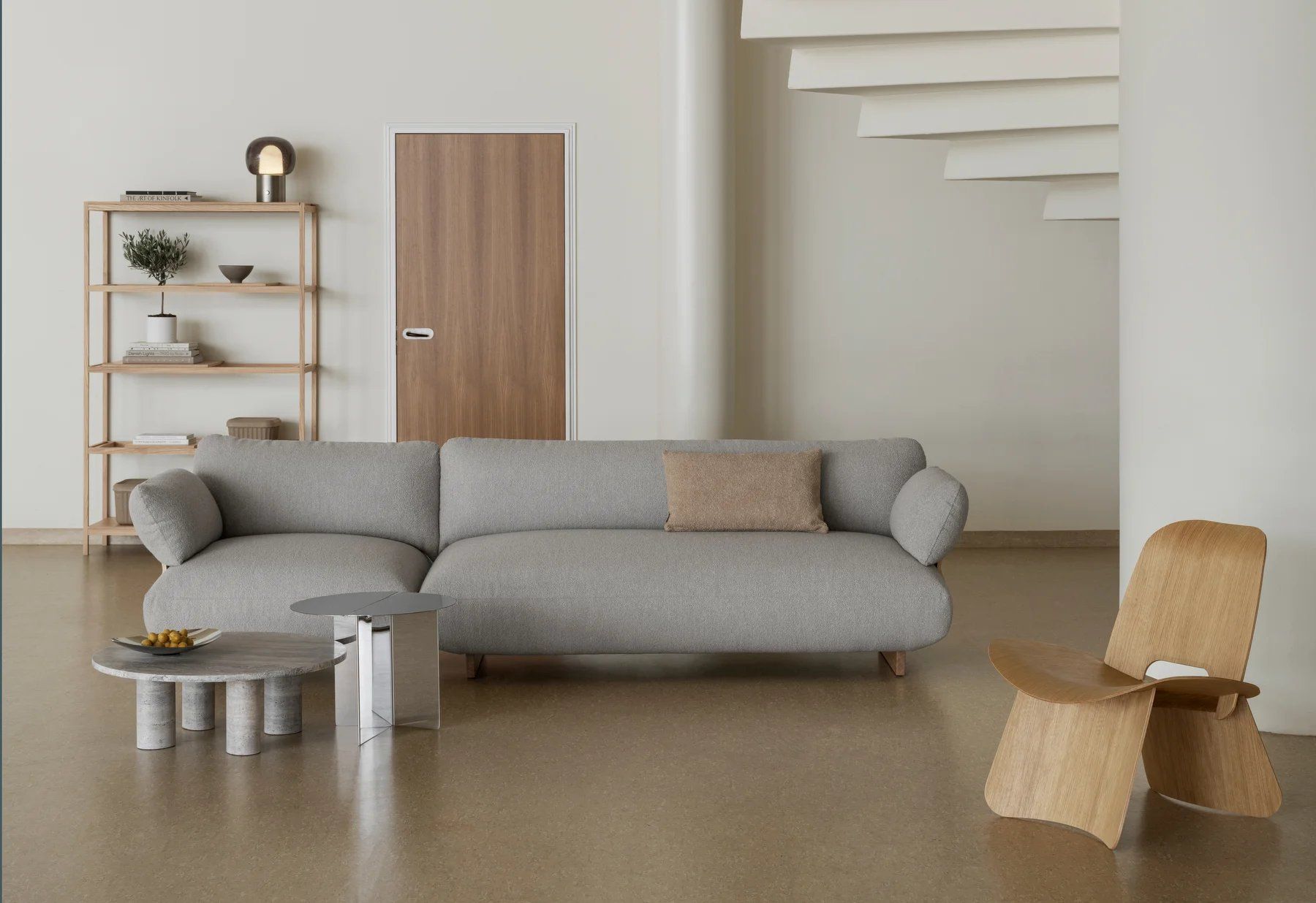 Blomus Nagomi Chair Stuhl aus hellem Holz im modernen Wohnzimmer mit Sofa und Regalen.