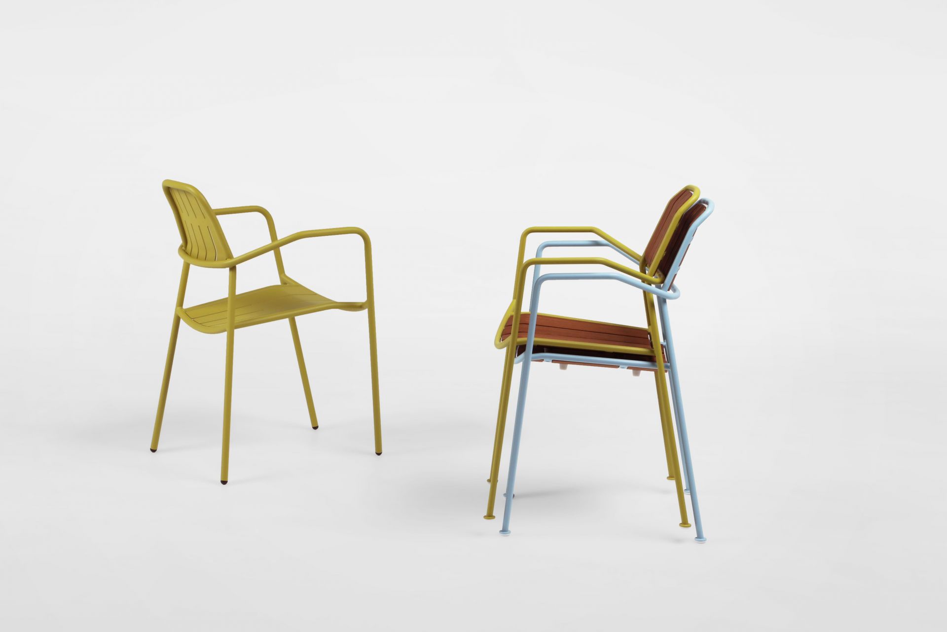 Zwei Osmo Outdoor Stühle von Prostoria: Einer gelb, einer blau mit Teakholz-Akzenten, moderne Gartenstühle.