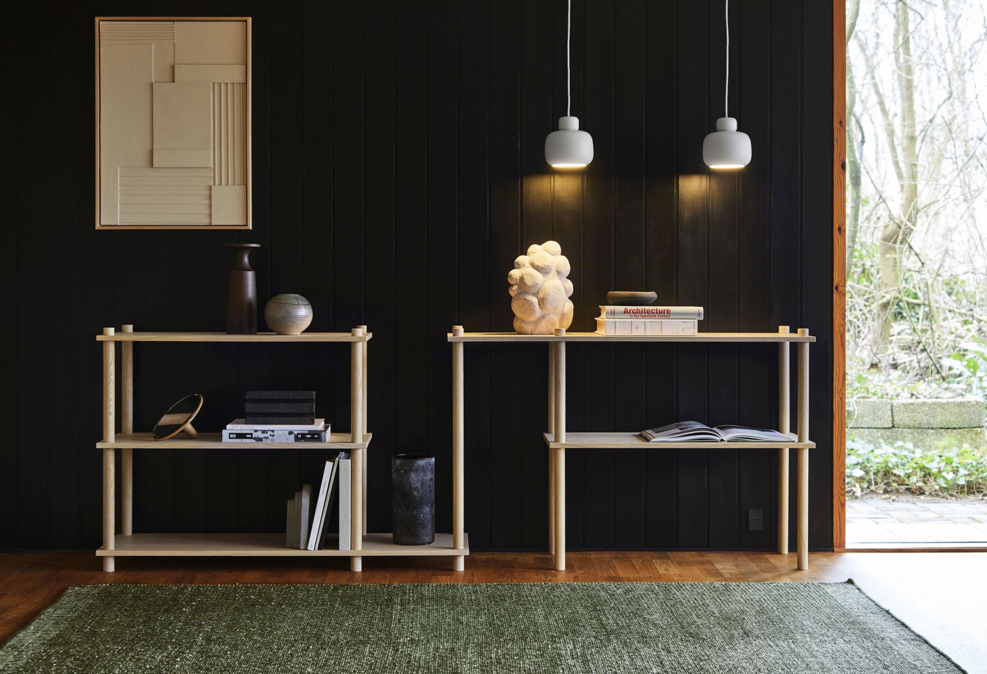 Zwei weiße Stone Pendant Pendelleuchten von Woud über Regalen vor dunkler Wand. Moderne Hängeleuchte.