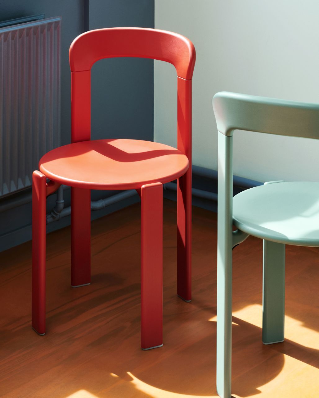 Nahaufnahme von zwei Stühlen, darunter ein roter Rey Chair Stuhl. Designermöbel für Esszimmer und Wohnbereich.