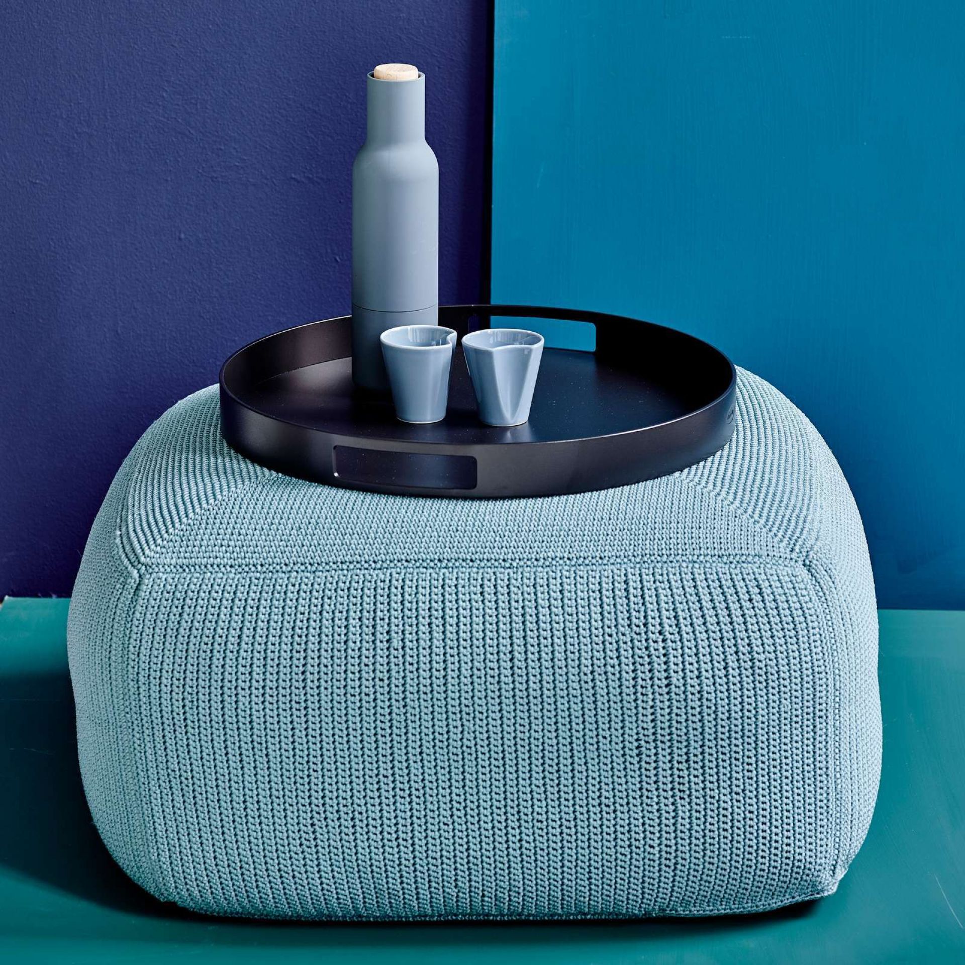 Cane-Line Serviertablett auf blauem Outdoor-Hocker mit Flasche und Gläsern für Garten und Terrasse.