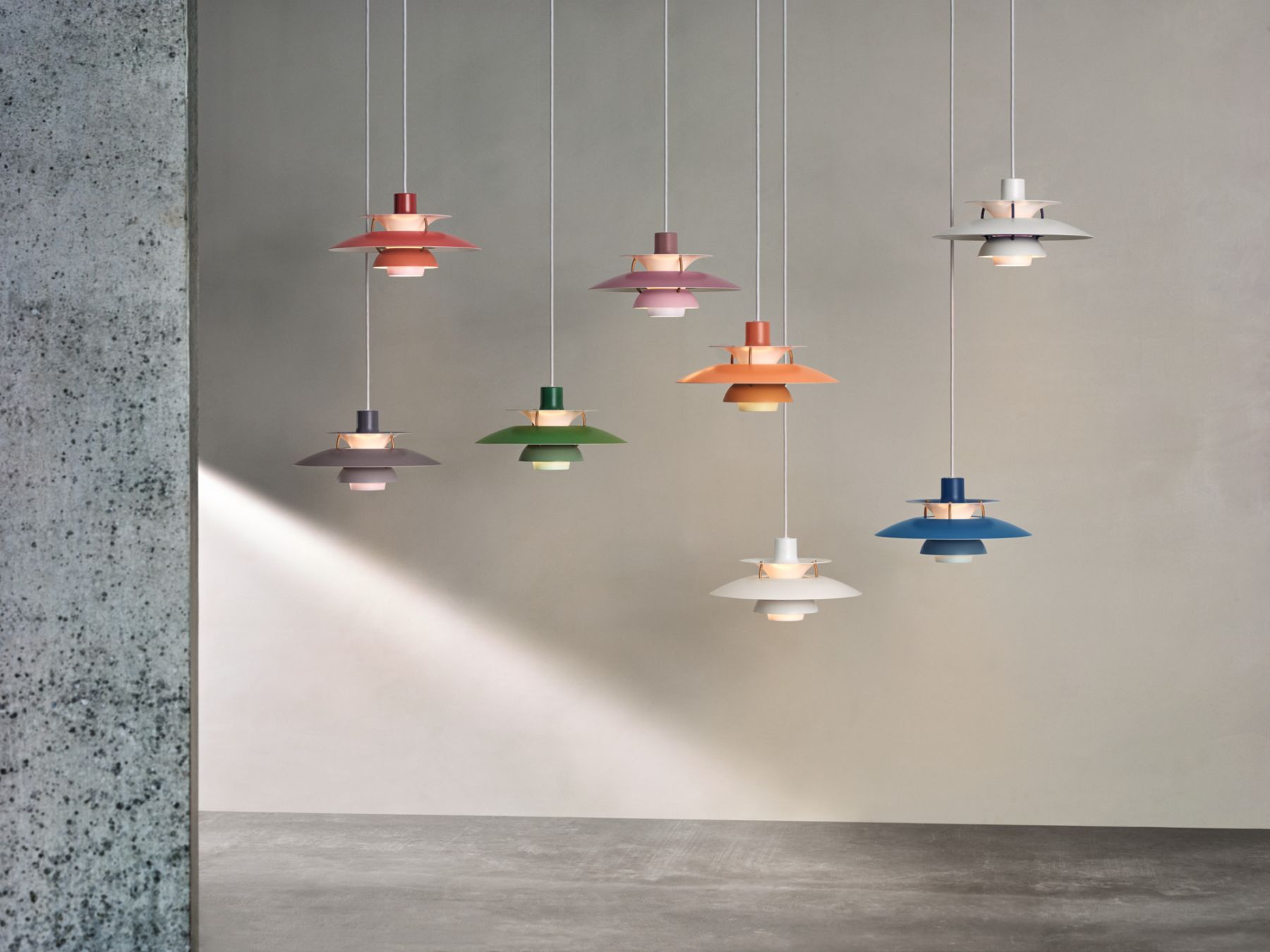 Mehrere farbige PH Mini Pendelleuchten von Louis Poulsen hängen im Raum. Design Lampe.