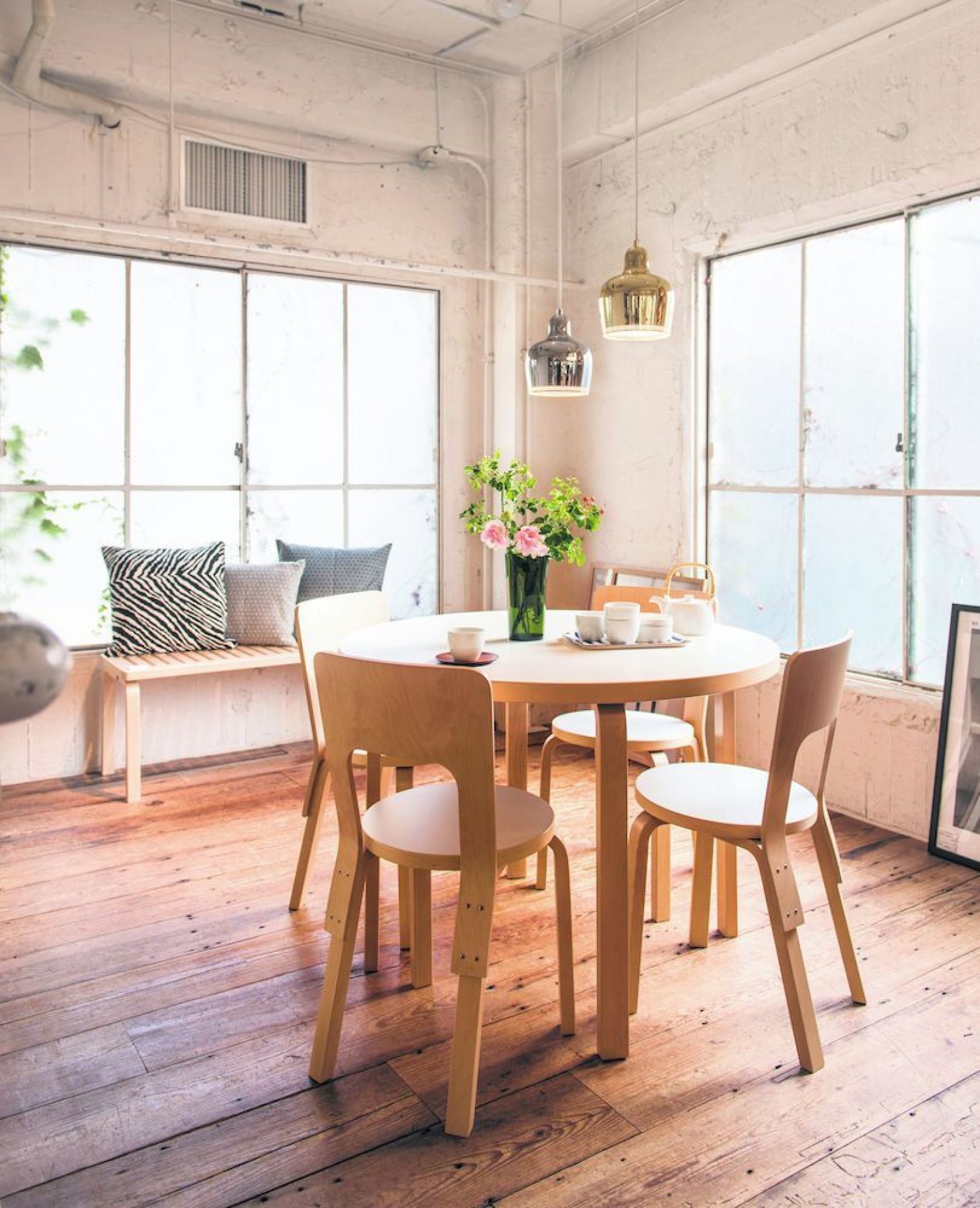Esszimmer mit A330S Golden Bell Pendelleuchten von Artek in Gold und Silber über Holztisch.