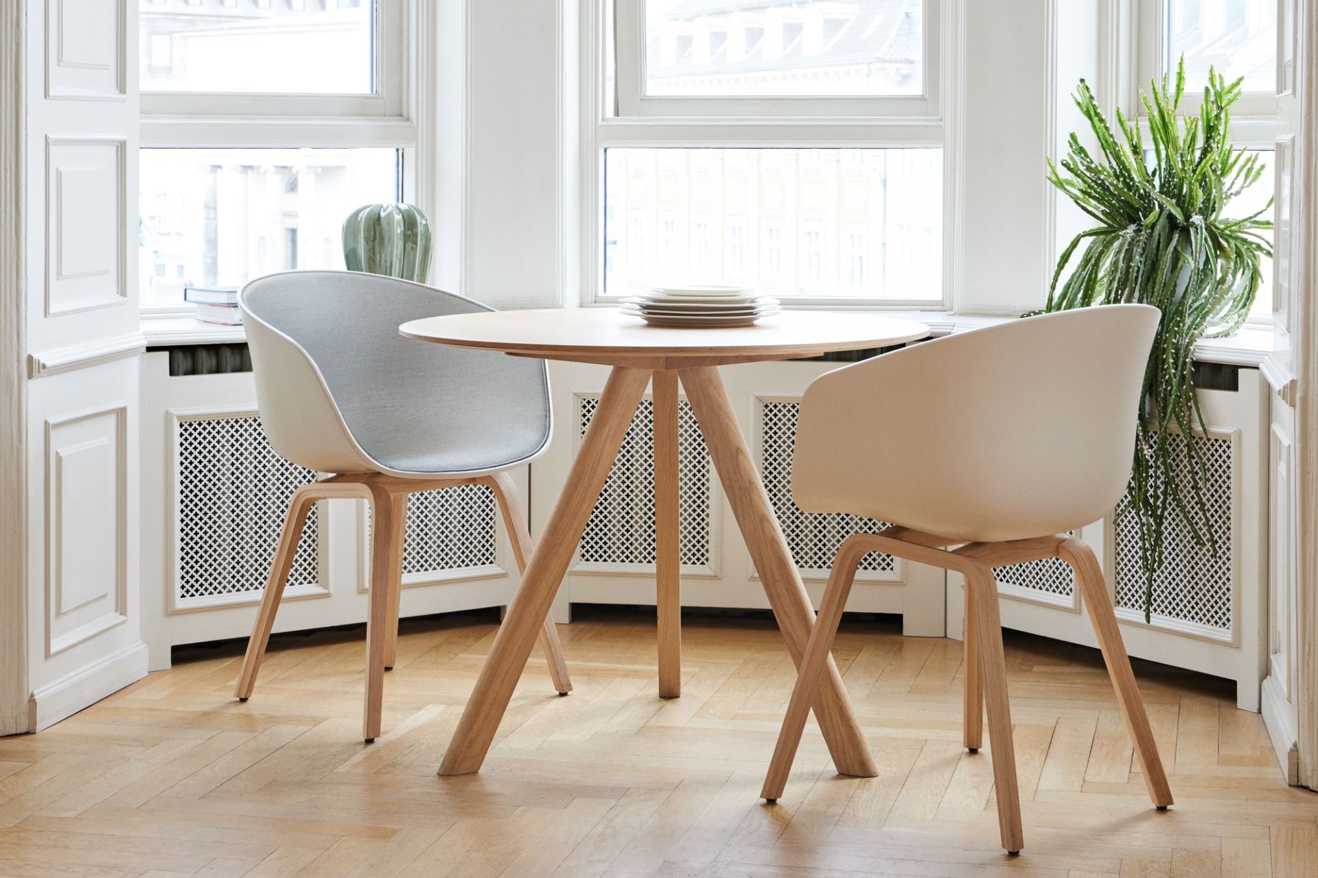 Heller Raum mit Copenhague Table CPH 20 Esstisch von Hay, runder Holztisch mit Design Stühlen.