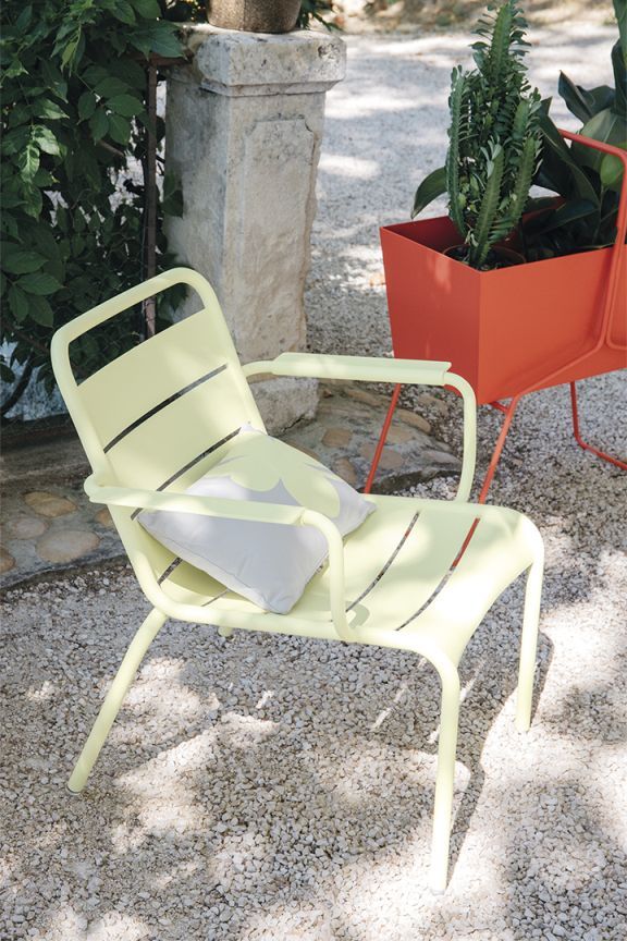Heller Luxembourg Lounge Sessel von Fermob mit Kissen im Garten, Outdoor Möbel.