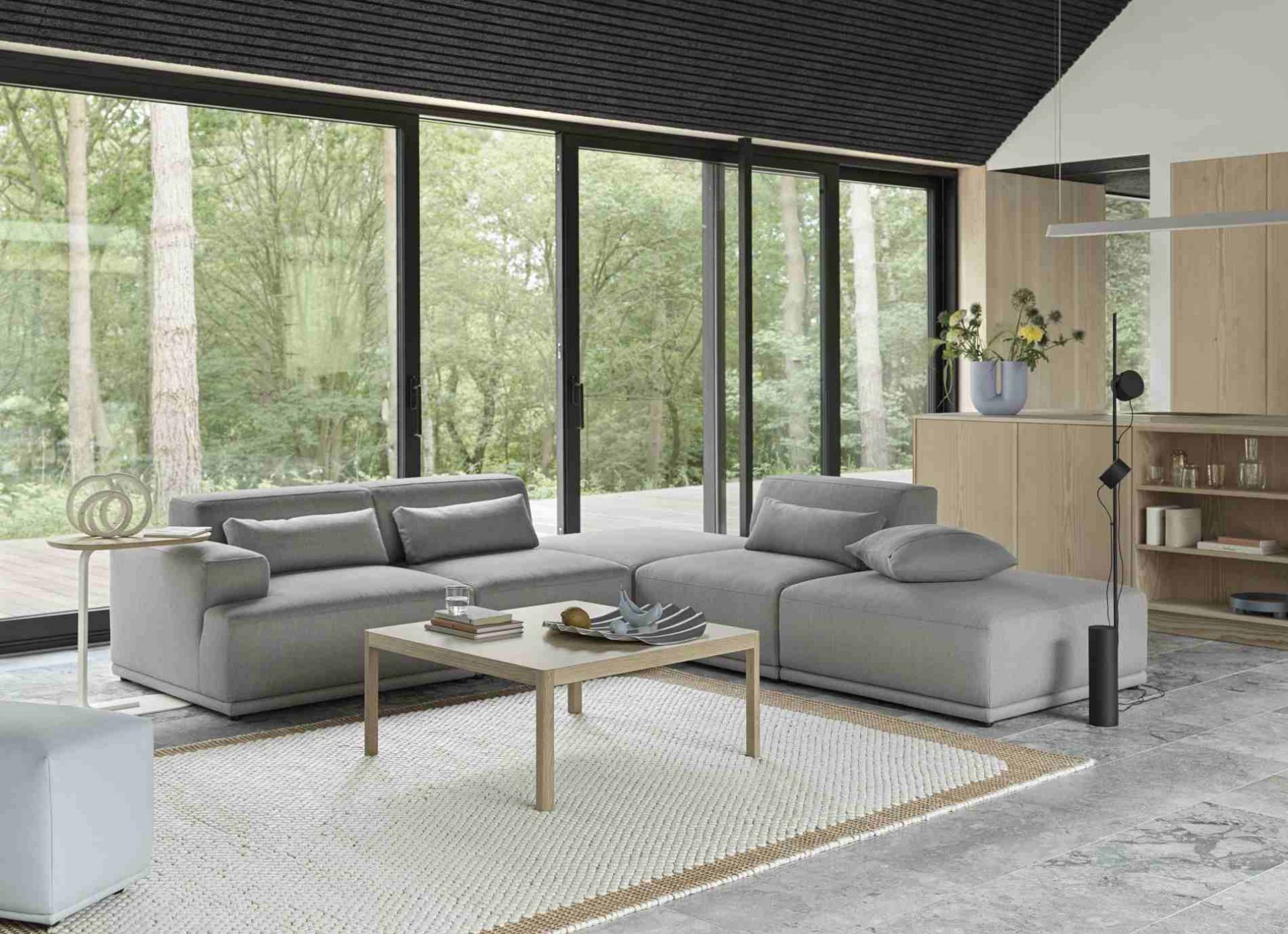 Graues Connect Soft Modular Sofa 3-Sitzer von Muuto im modernen Wohnzimmer mit Teppich und Couchtisch.