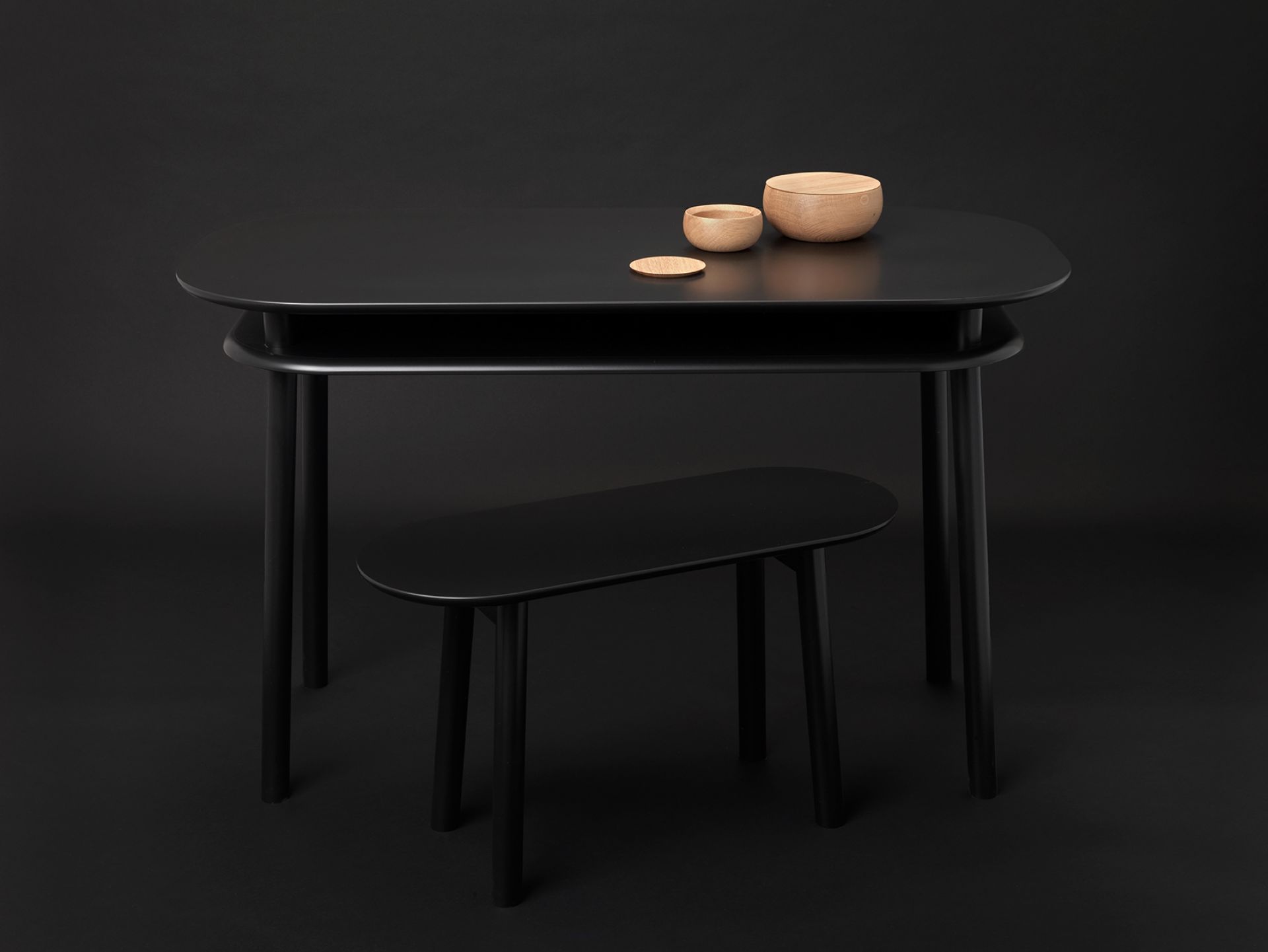 Schwarzer Schönbuch Schreibtisch mit Holzschalen und Hocker, minimalistisches Design für modernes Arbeitszimmer.