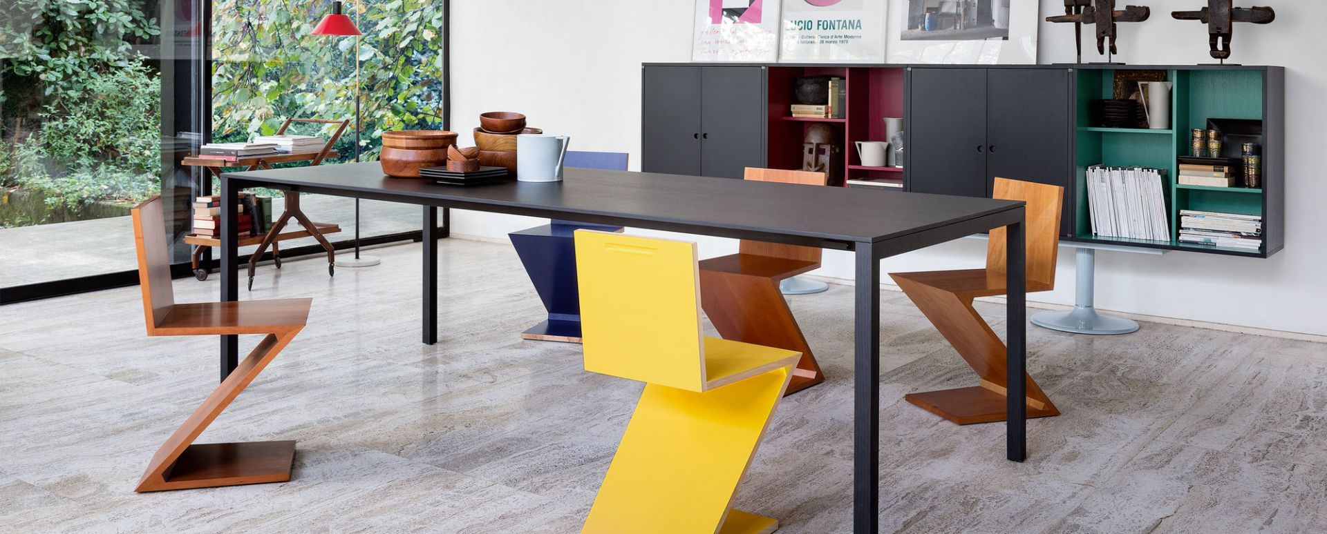 Cassina Zig Zag Stühle in Gelb und Holz um einen Esstisch in modernem Interieur.