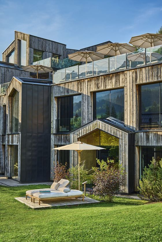 Weishäupl Sonnenschirm Klassiker im Garten mit Liegen vor modernem Holzhaus, ideal für entspannte Sommertage.