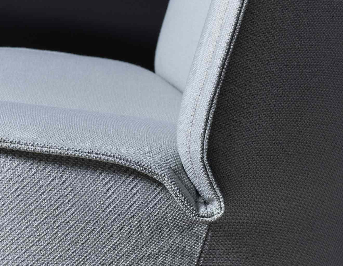 Detailaufnahme des grauen Nenou Sessels von Cor mit hochwertiger Stoffpolsterung und feinen Ziernähten.