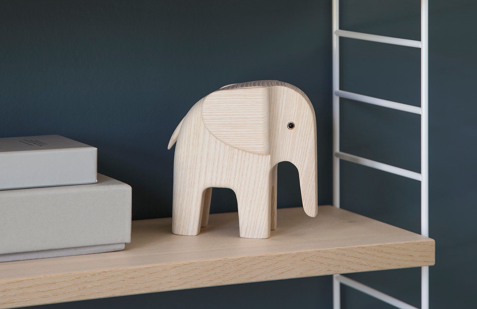 Baby Elefant Natur von Novoform aus hellem Holz als Deko-Objekt auf einem Regal.