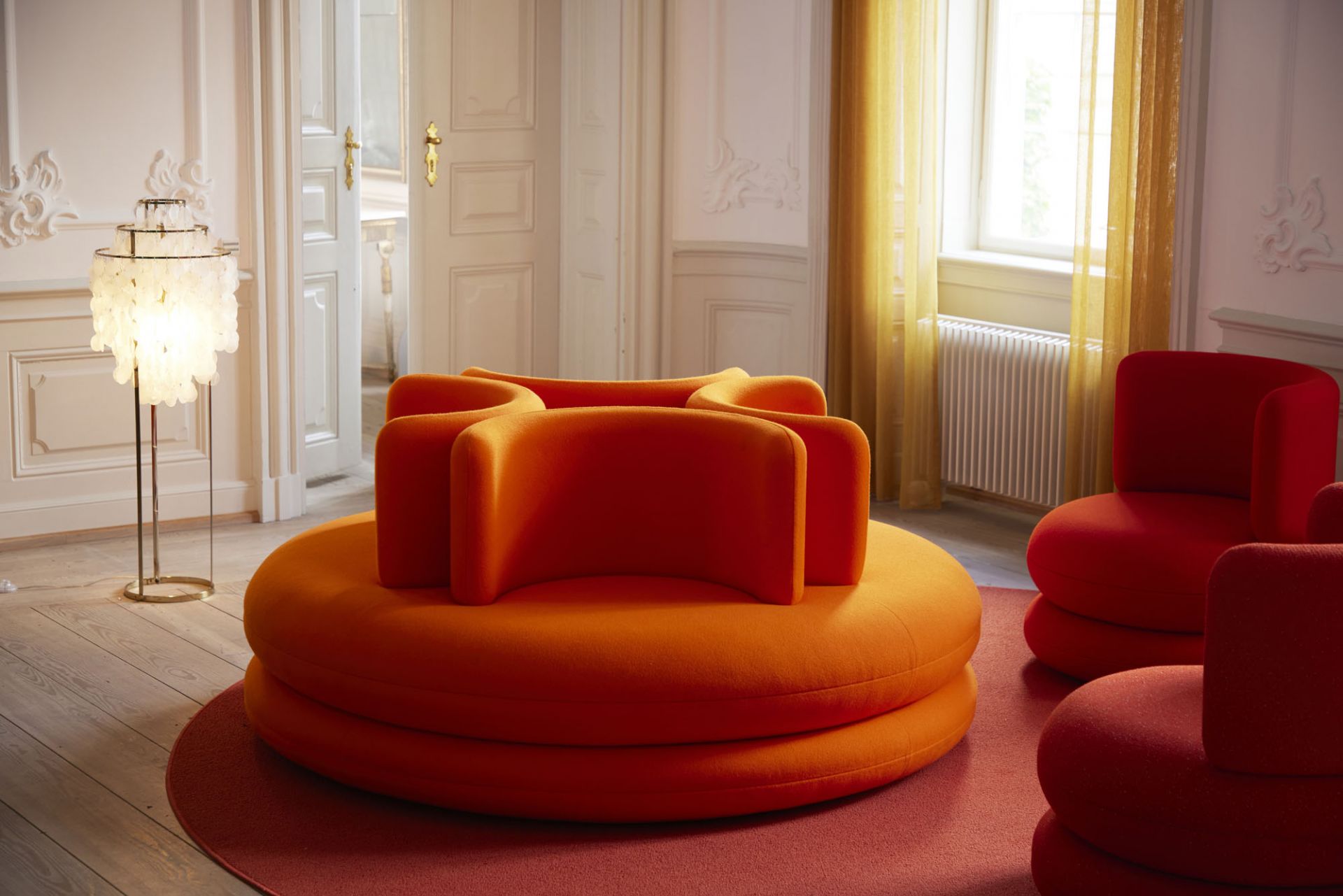 Orangefarbenes Easy Sofa von Verpan in modernem Wohnzimmer mit rotem Teppich und Sesseln.