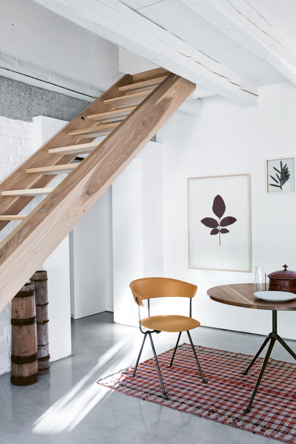 Heller Raum mit Magis Stuhl, braunem Leder, schwarzem Metallgestell und Holztisch. Designermöbel.