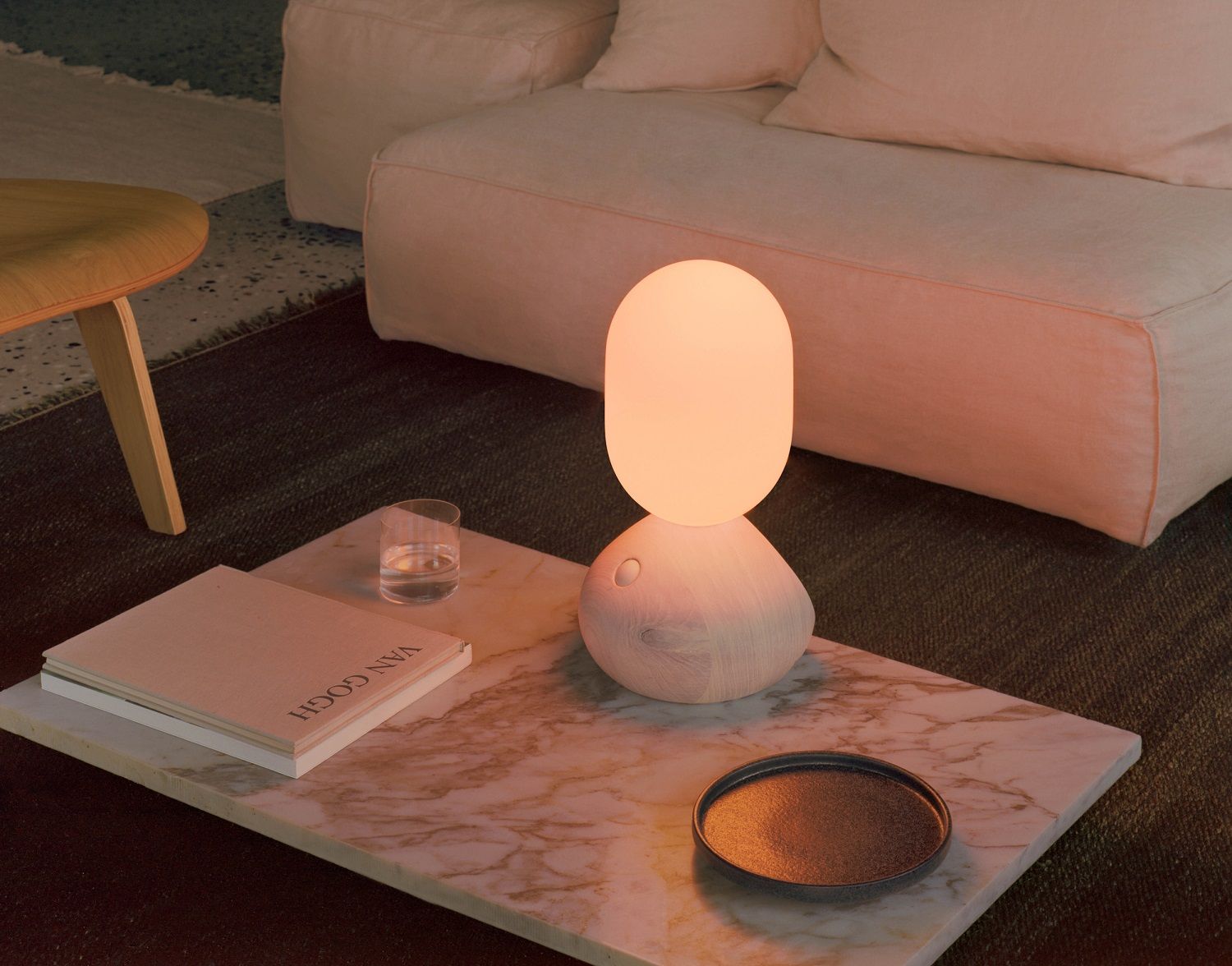Nahaufnahme der Sun Home Lichtskulptur in Grau auf einem Marmortisch, stimmungsvolle Tischleuchte.