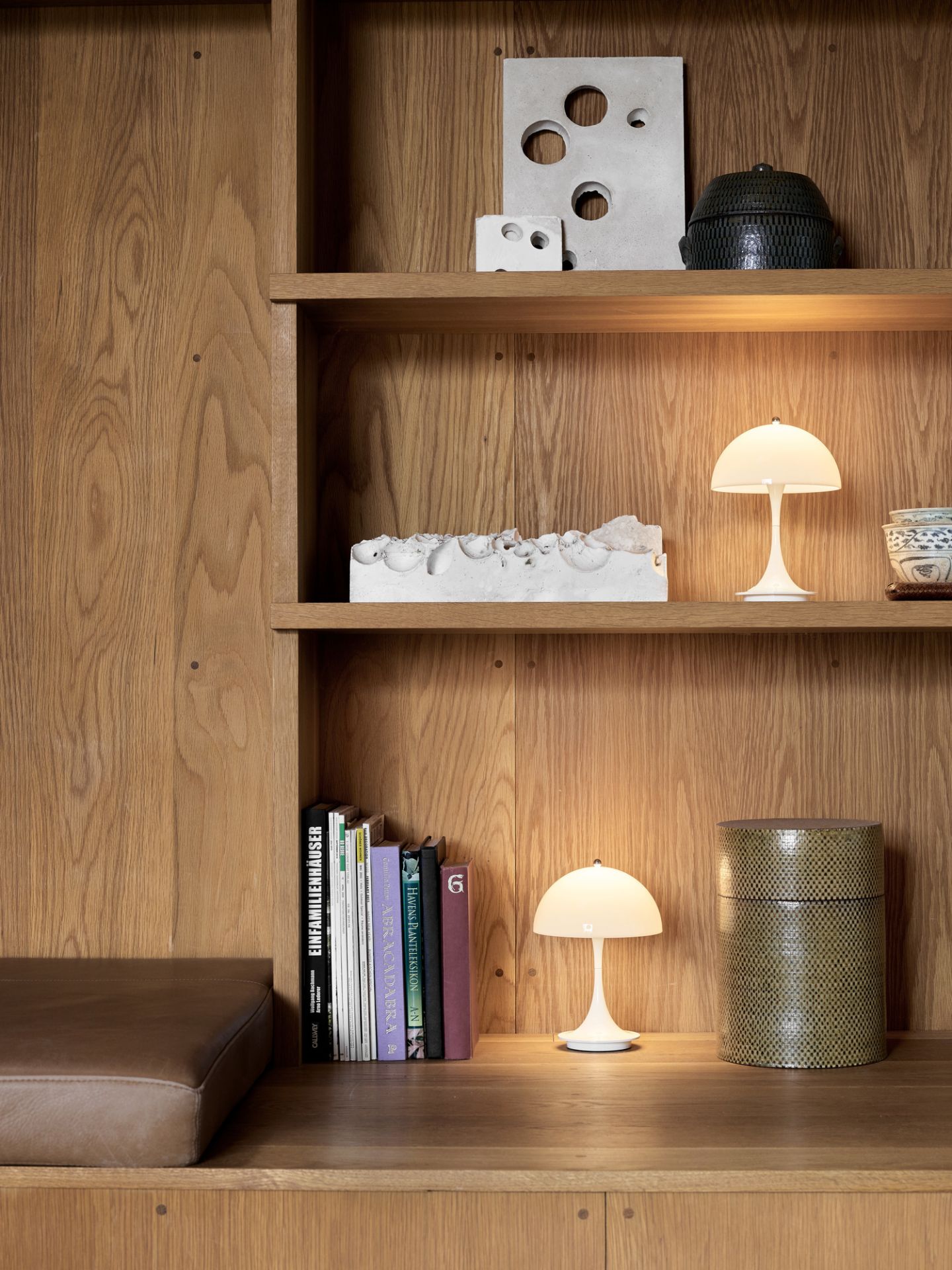 Panthella 160 Portable LED-Tischleuchte in Opal Grau auf einem Holzregal. Designleuchte für Indoor und Outdoor.