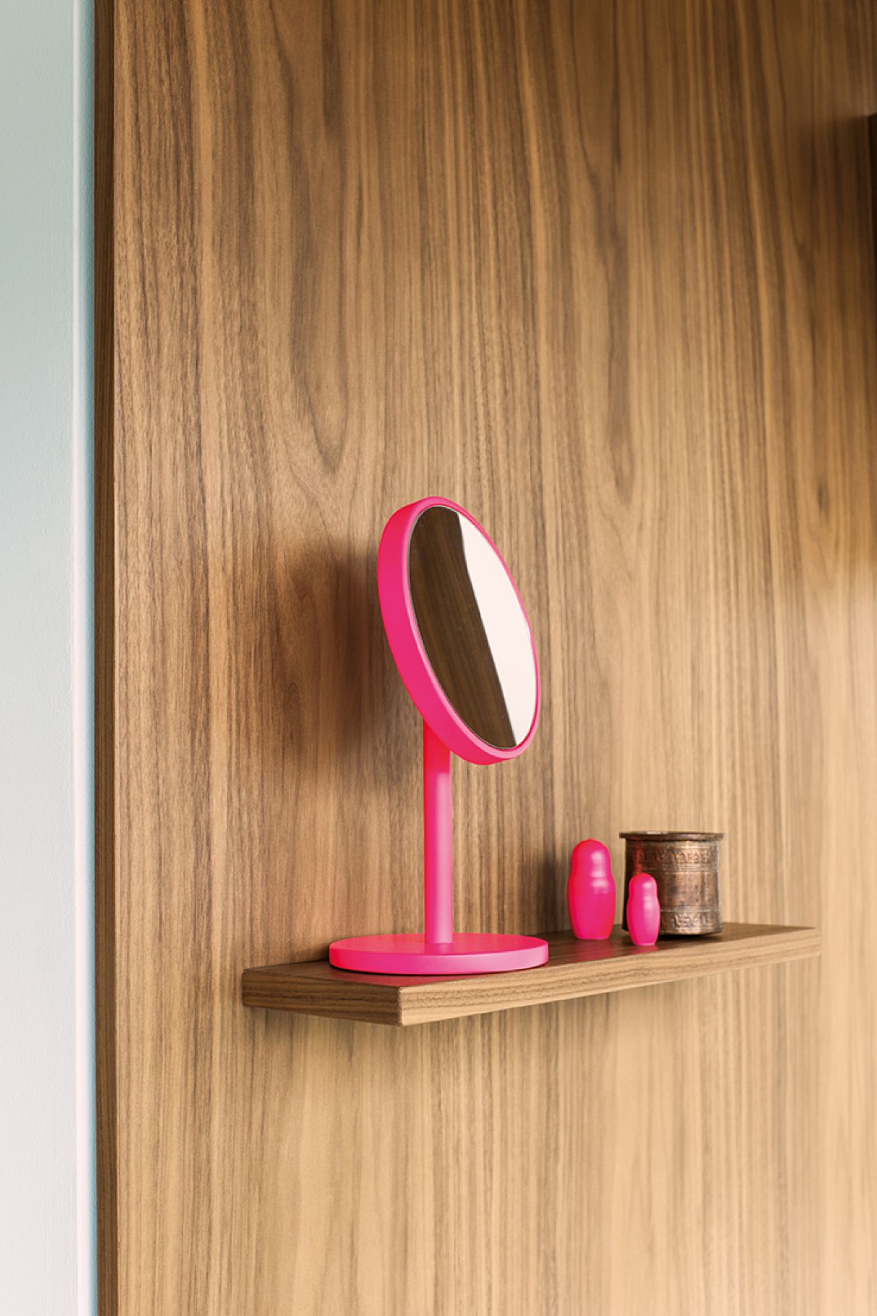 Pinker Schönbuch Schminkspiegel auf Holzregal vor einer Holzwand, mit Deko-Elementen.