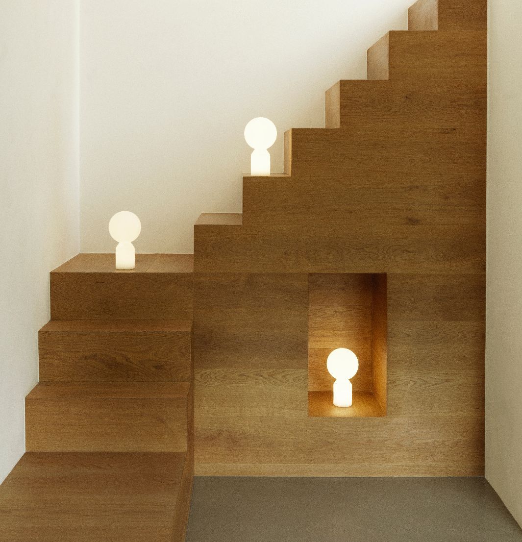 Drei Yo Lamp Small Akkuleuchten von Normann Copenhagen auf einer Holztreppe, warmes, stimmungsvolles Licht.