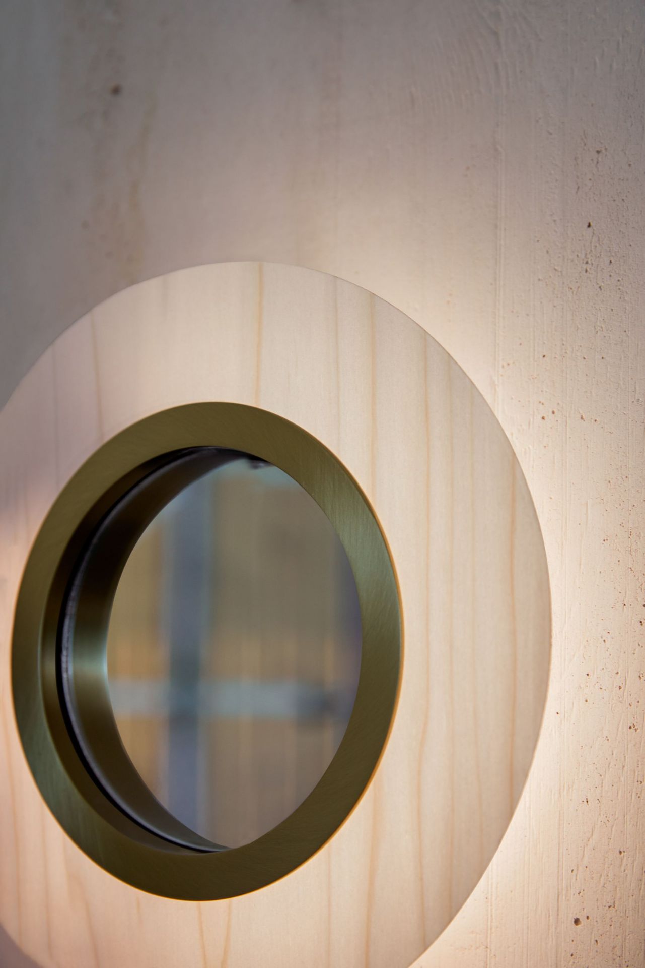 Lens LED Wandleuchte von LZF Lamps: Runde, elfenbeinweiße Holzleuchte mit hellrosa Akzenten und Metallring.