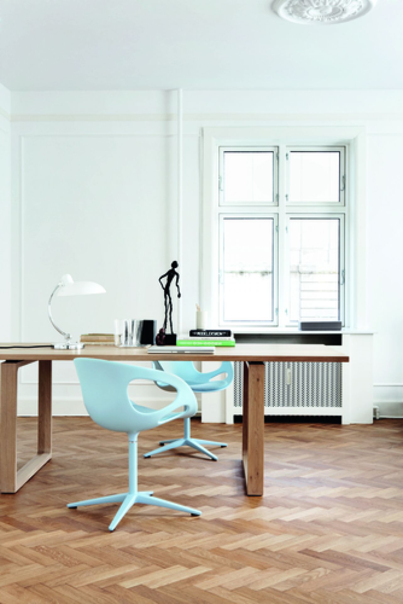 Heller Raum mit Essay Tisch von Fritz Hansen und zwei hellblauen Stühlen.