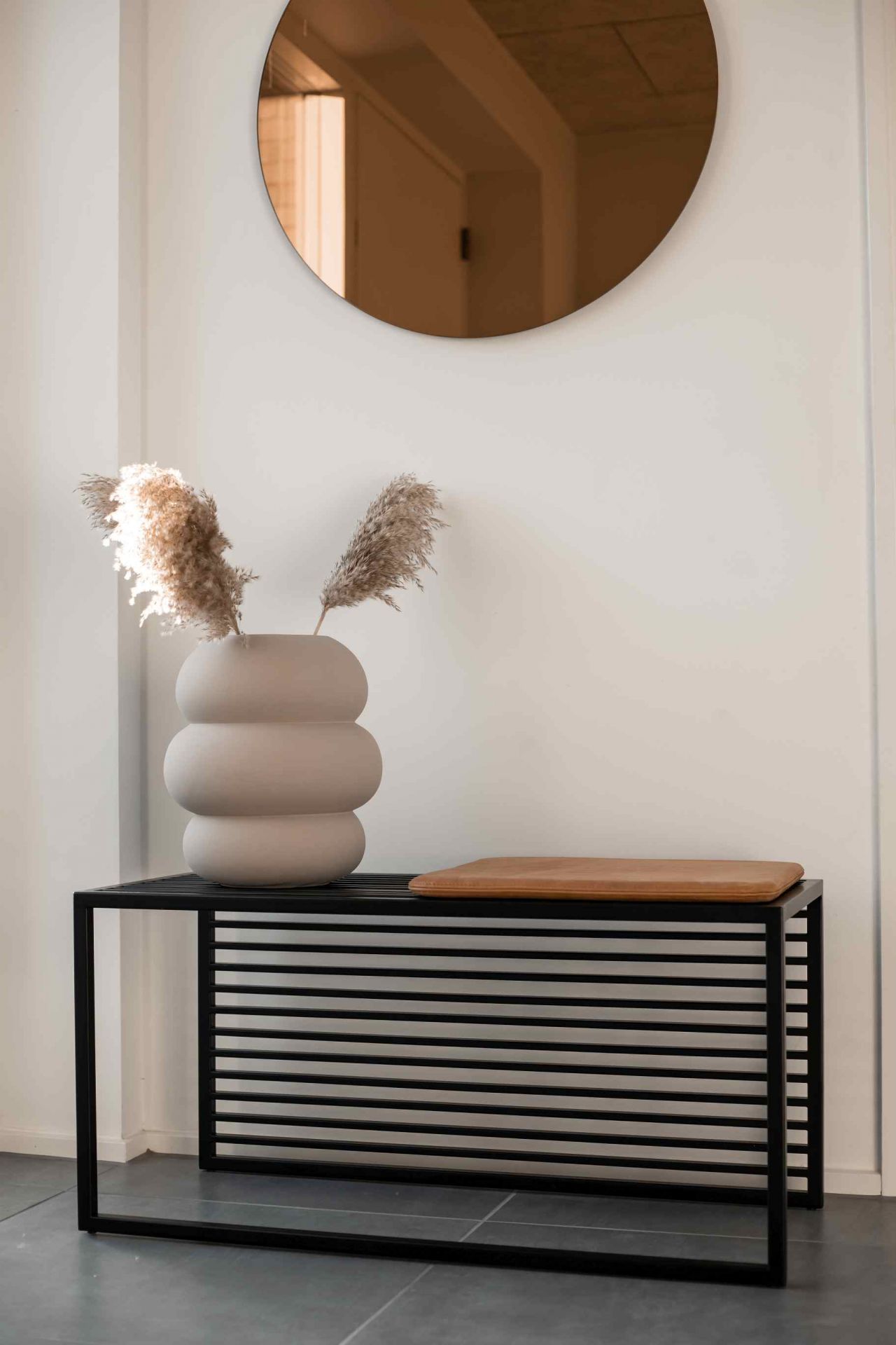 Element Bench Bank novoform mit schwarzem Metallgestell, Holzauflage und dekorativer Vase im modernen Interieur.