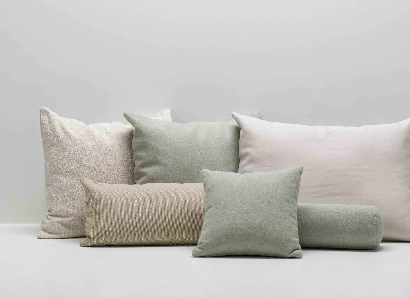 Vitra Kissen und Sofakissen in verschiedenen Formen und Texturen in Beige, Weiß und Grün.